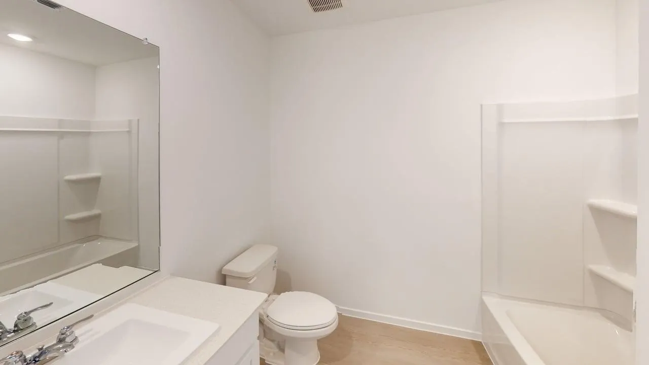 White vanity with an integrated sink, polished chrome faucet, and expansive wall-mounted mirror