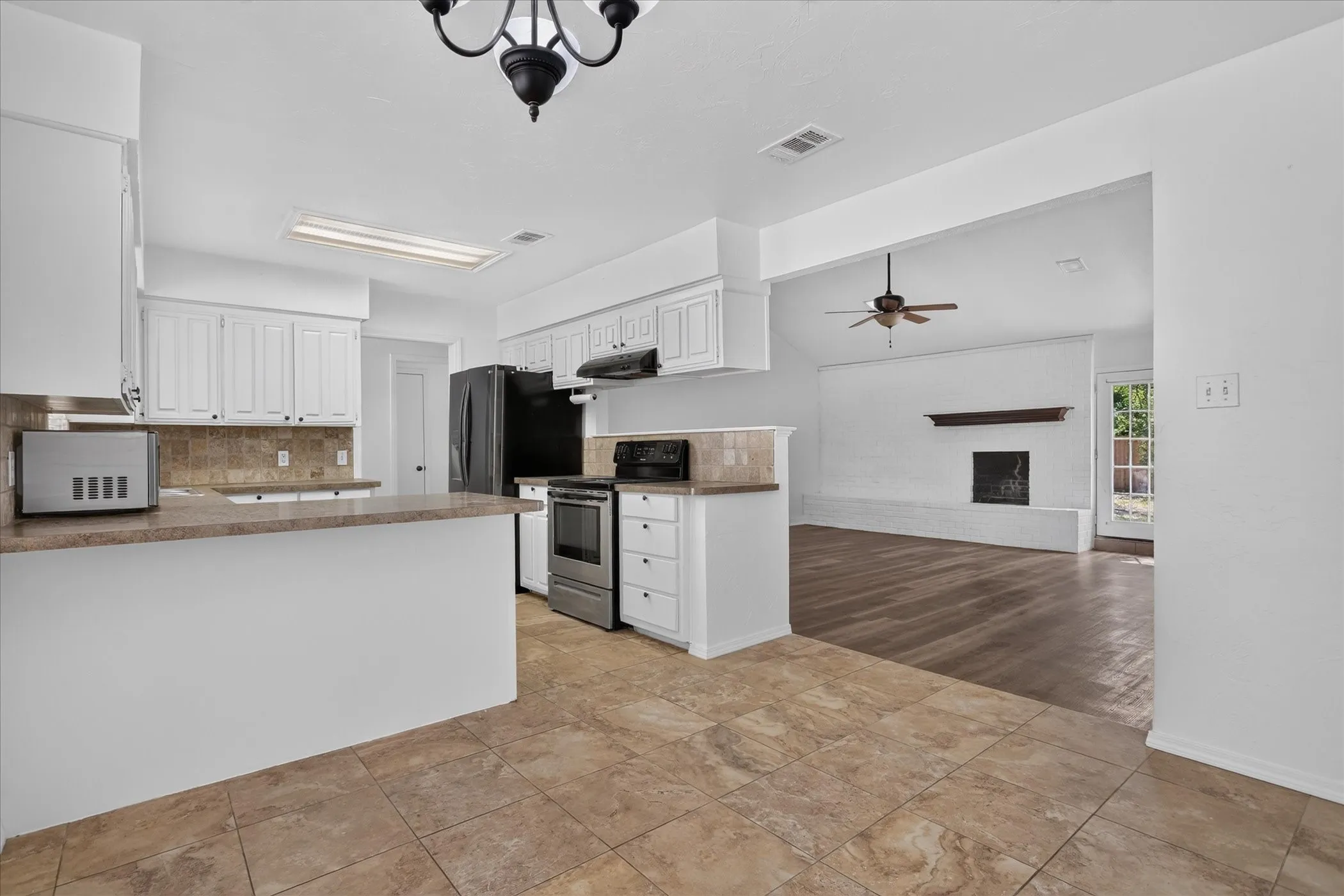 Kitchen featuring white cabinetry, tile flooring, and a breakfast bar