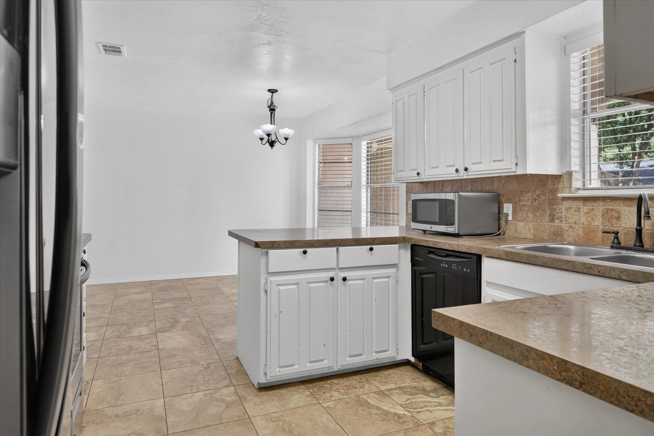 Kitchen featuring white cabinetry, tile countertops, tile backsplash, and tile flooring