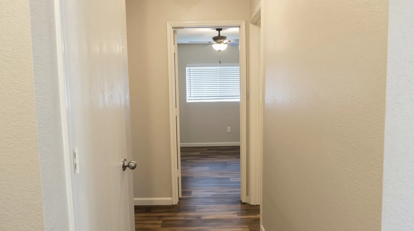 Wood-finish flooring, ceiling fan, window with blinds