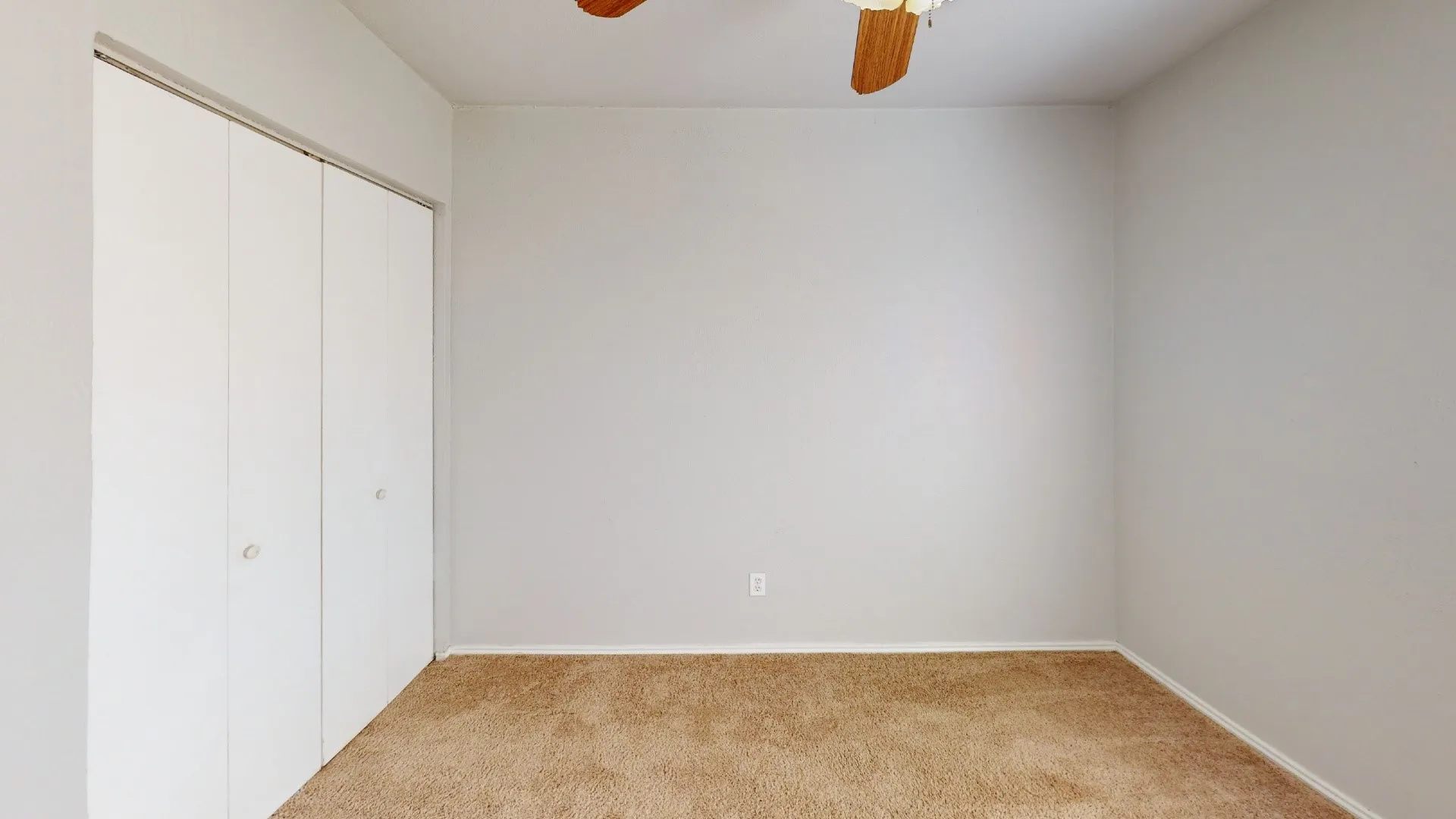Carpeted flooring, bi-fold closet, ceiling fan, and light-toned walls