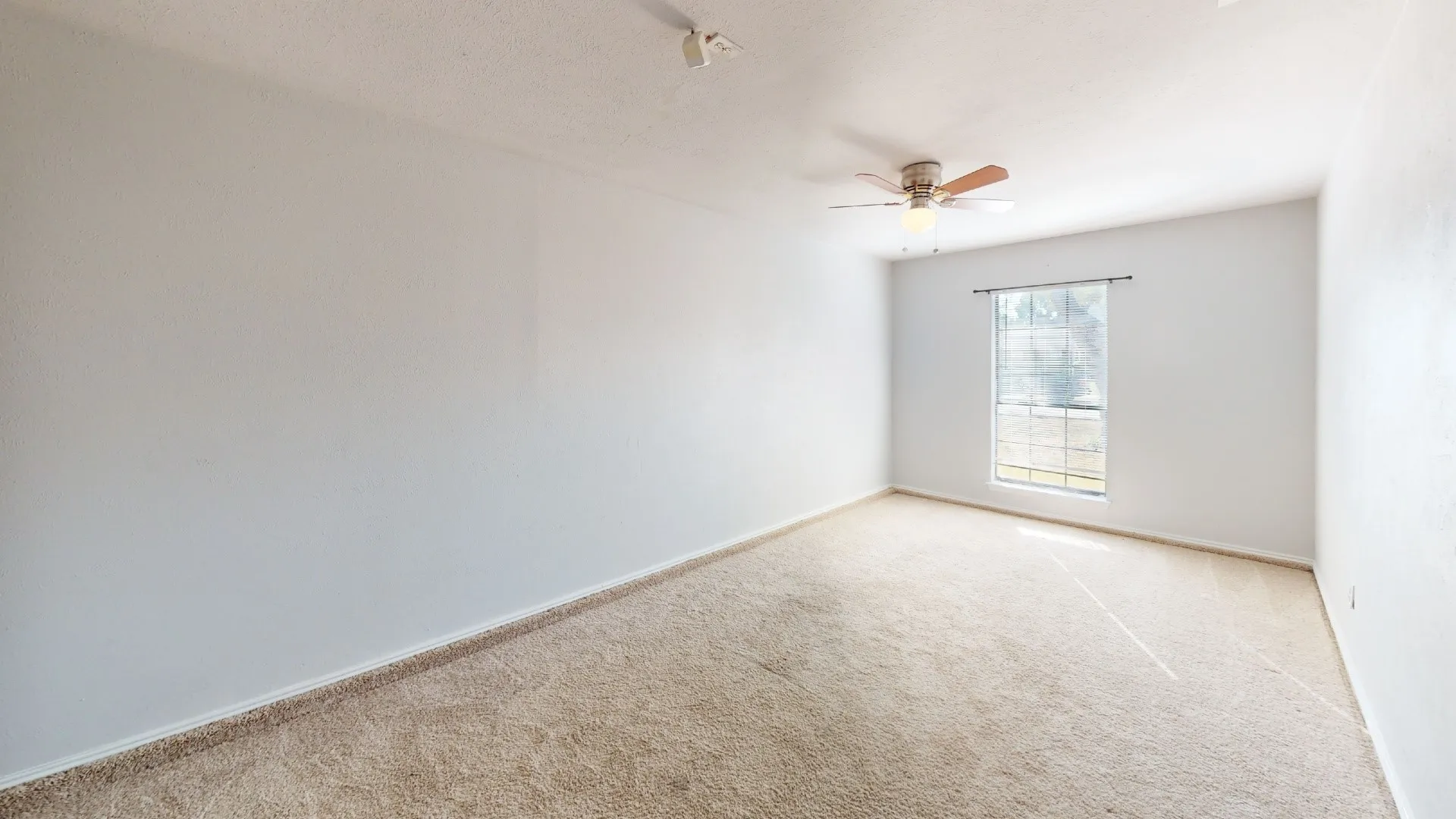 Wall-to-wall carpeting and a ceiling fan with integrated lighting