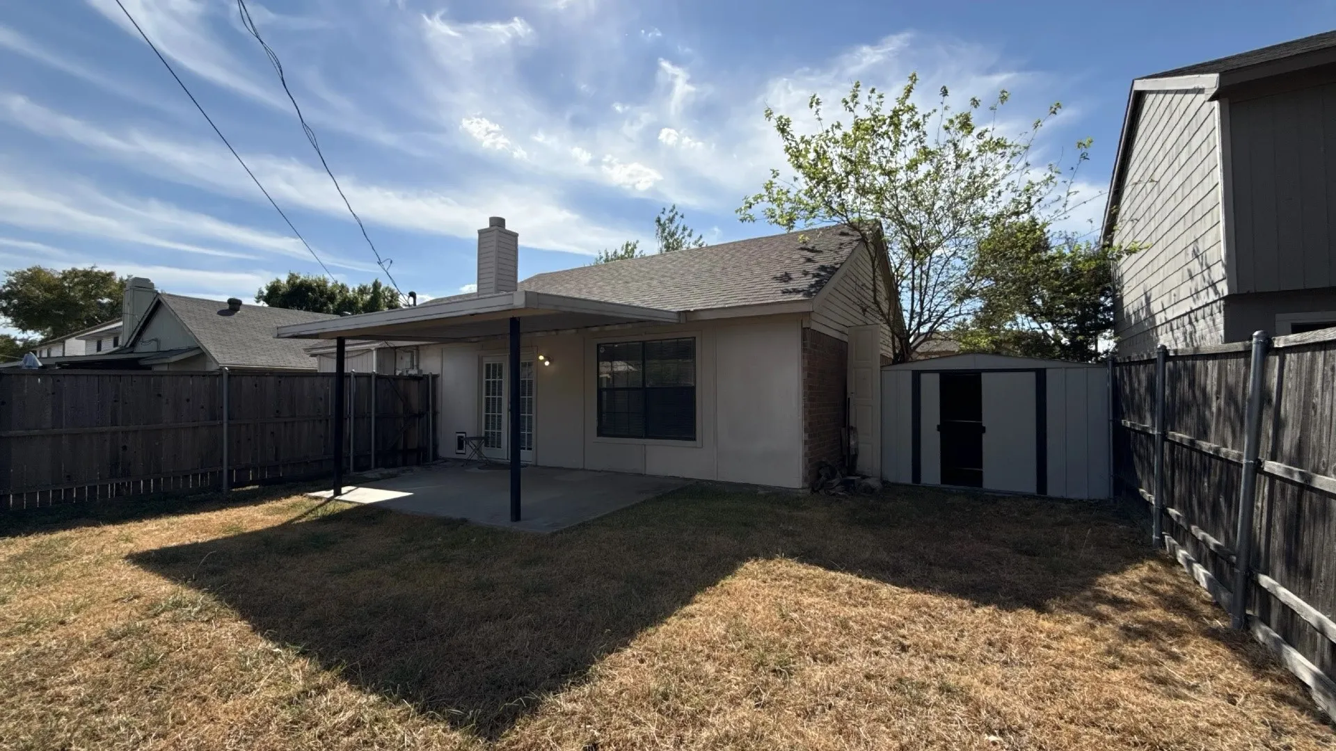 Covered patio with concrete flooring, private backyard, and a storage shed