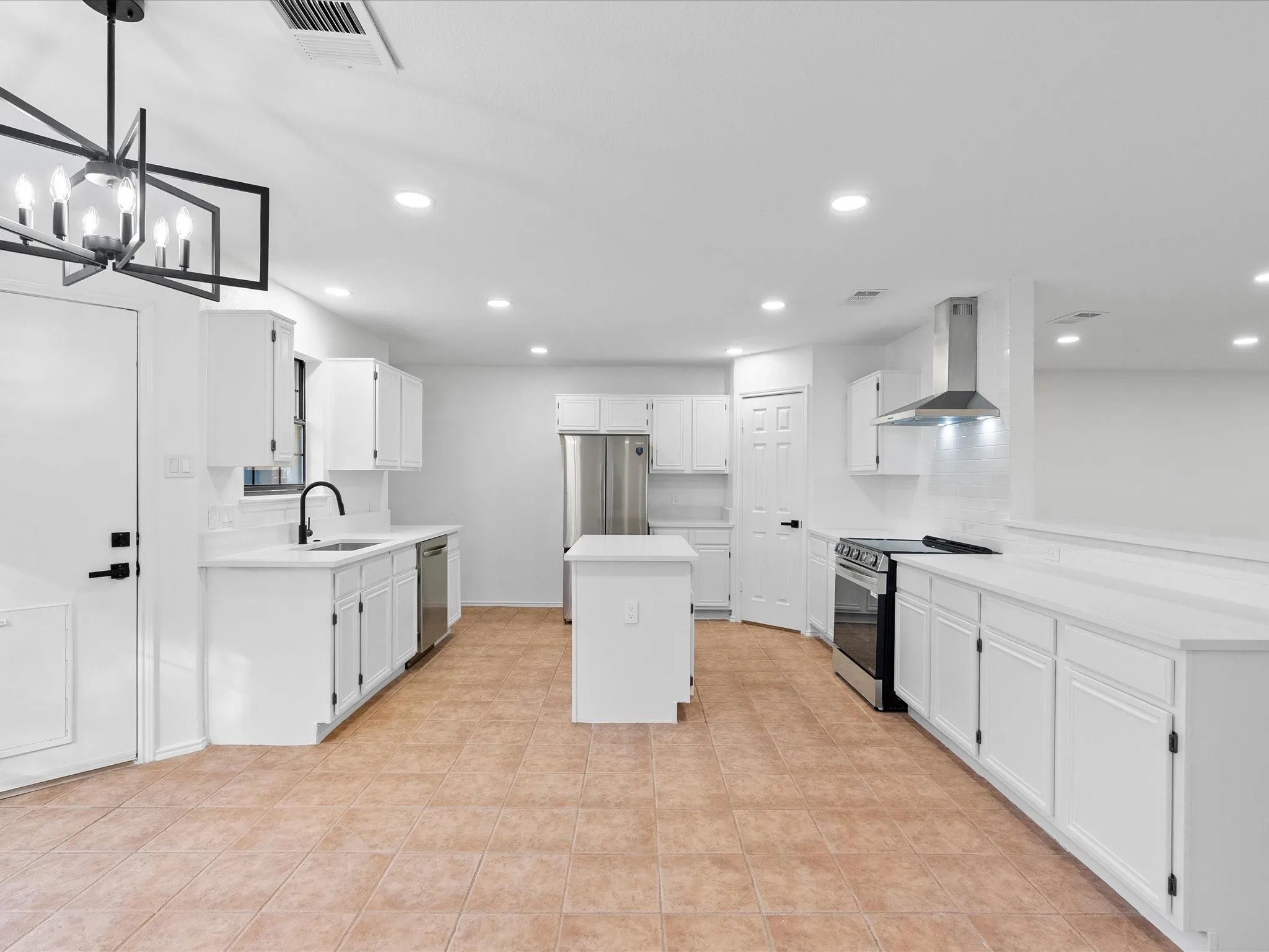 Kitchen featuring white cabinetry, stainless steel appliances, a center island, recessed lighting, and tile flooring