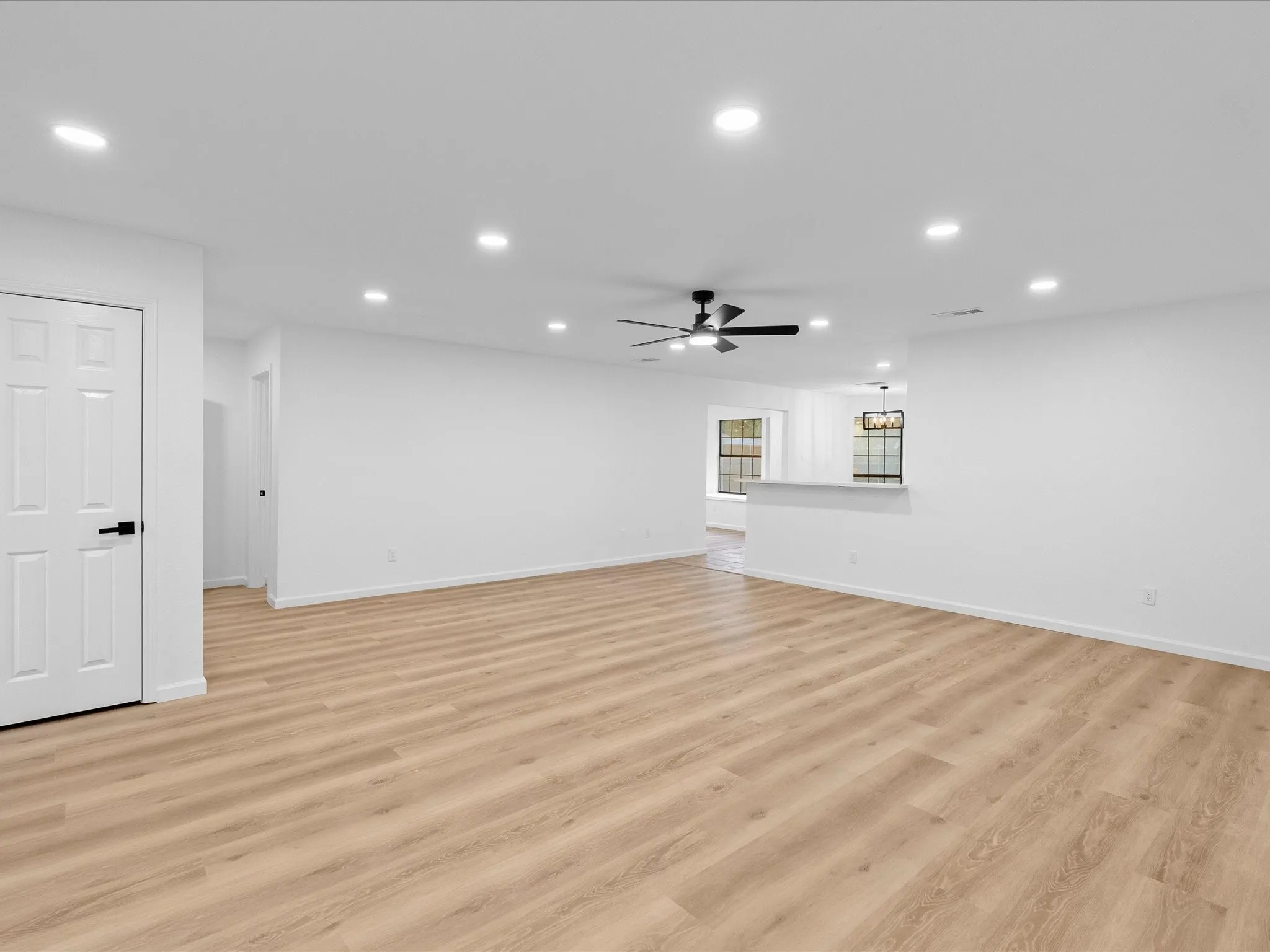 Spacious living area featuring wood-finish flooring, recessed lighting, and a modern ceiling fan