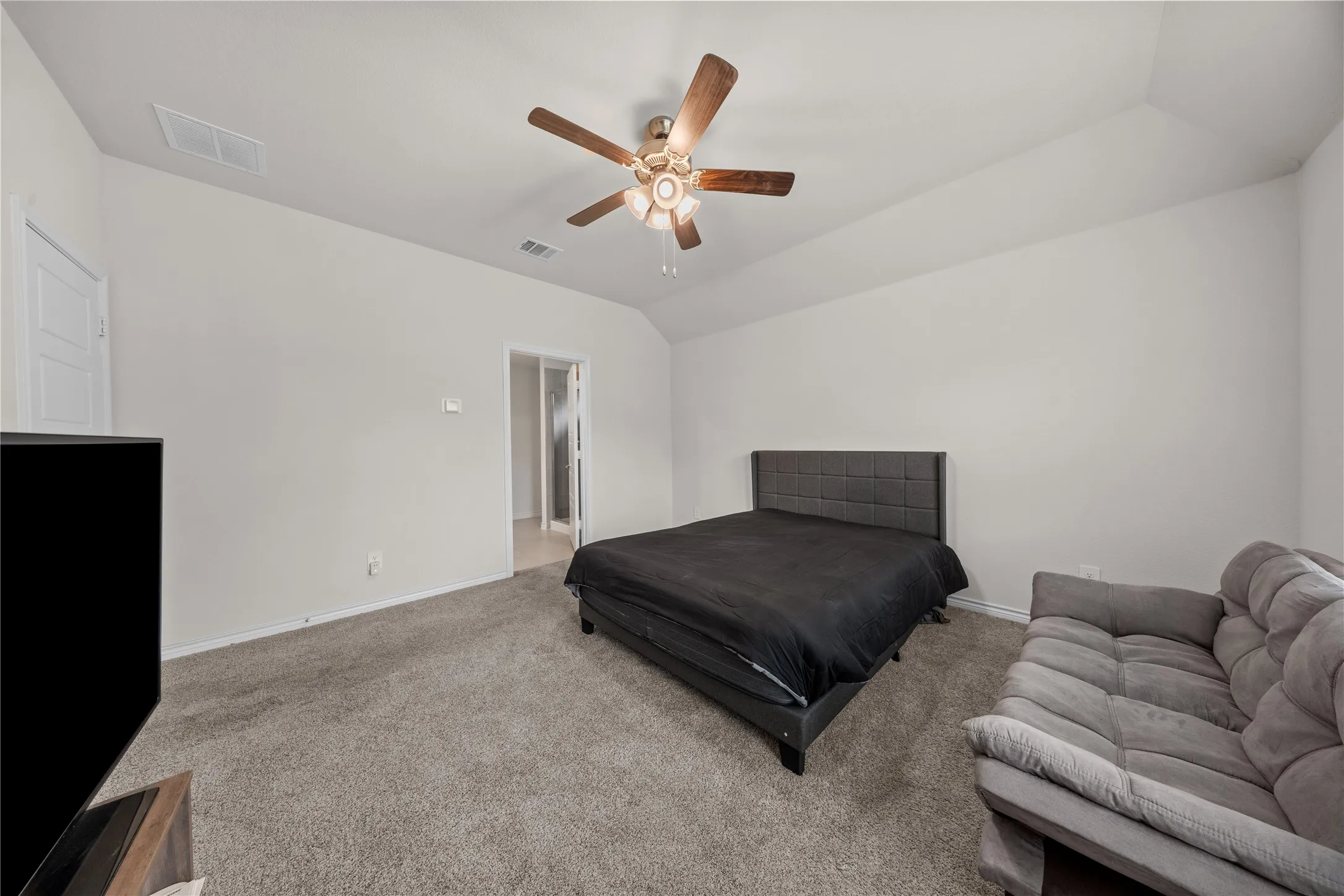 Carpeted flooring, vaulted ceiling, and a ceiling fan with integrated lighting