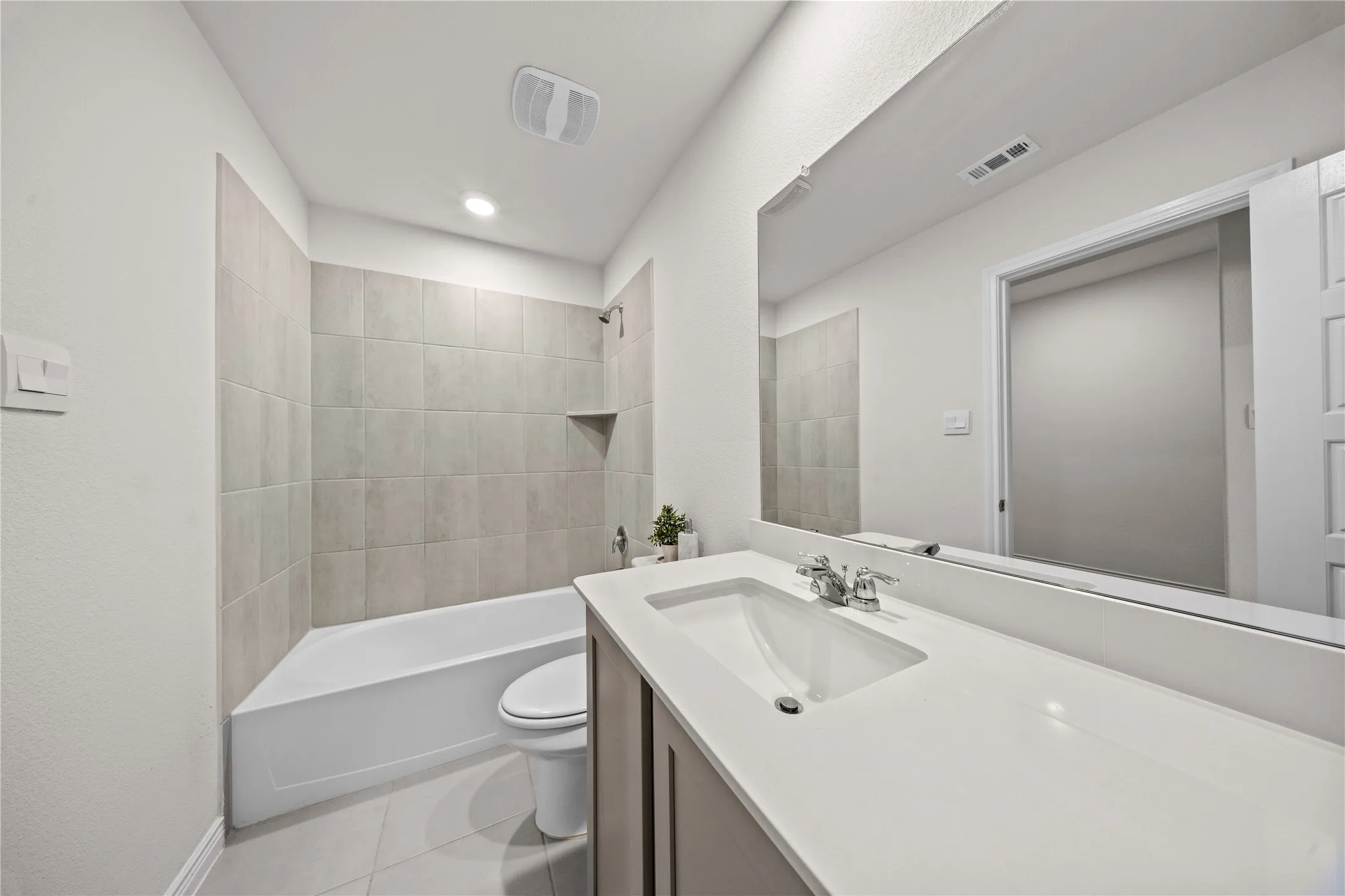 Integrated bathtub with subway tile surround and corner shelf