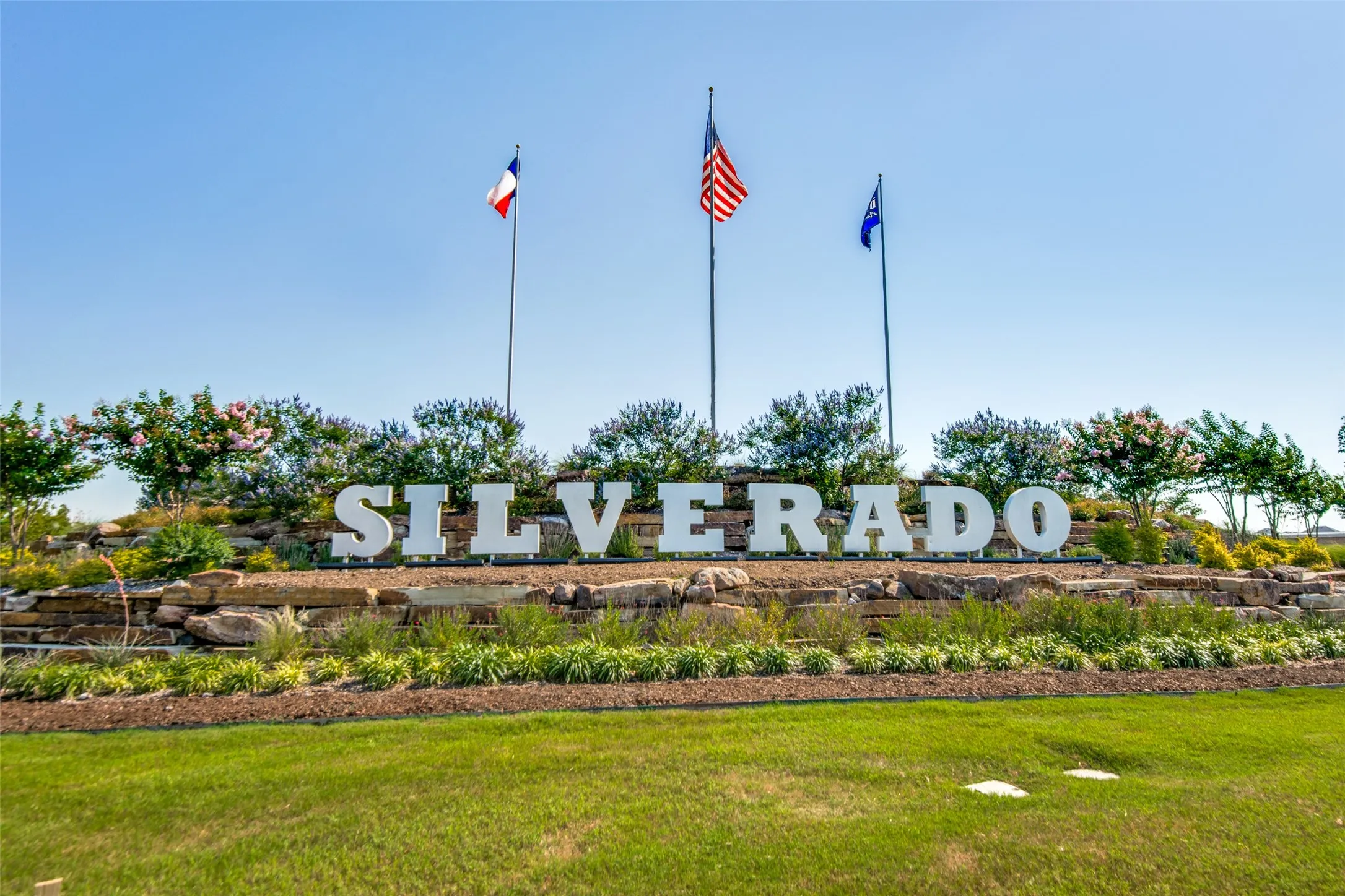 Silverado community entrance sign featuring stacked stone landscaping and mature plantings