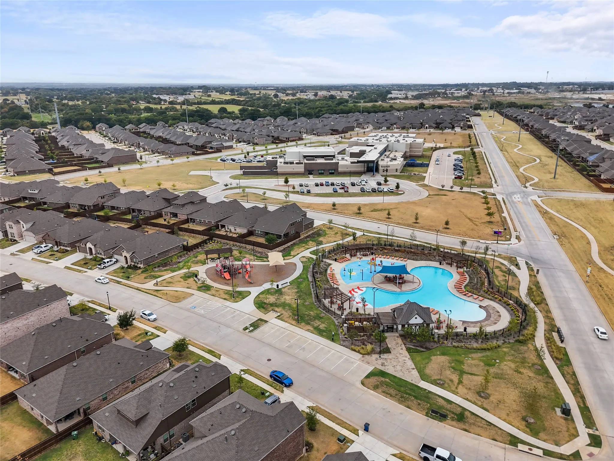 Community amenities featuring a large swimming pool, splash pad, playground, and extensive paved pathways