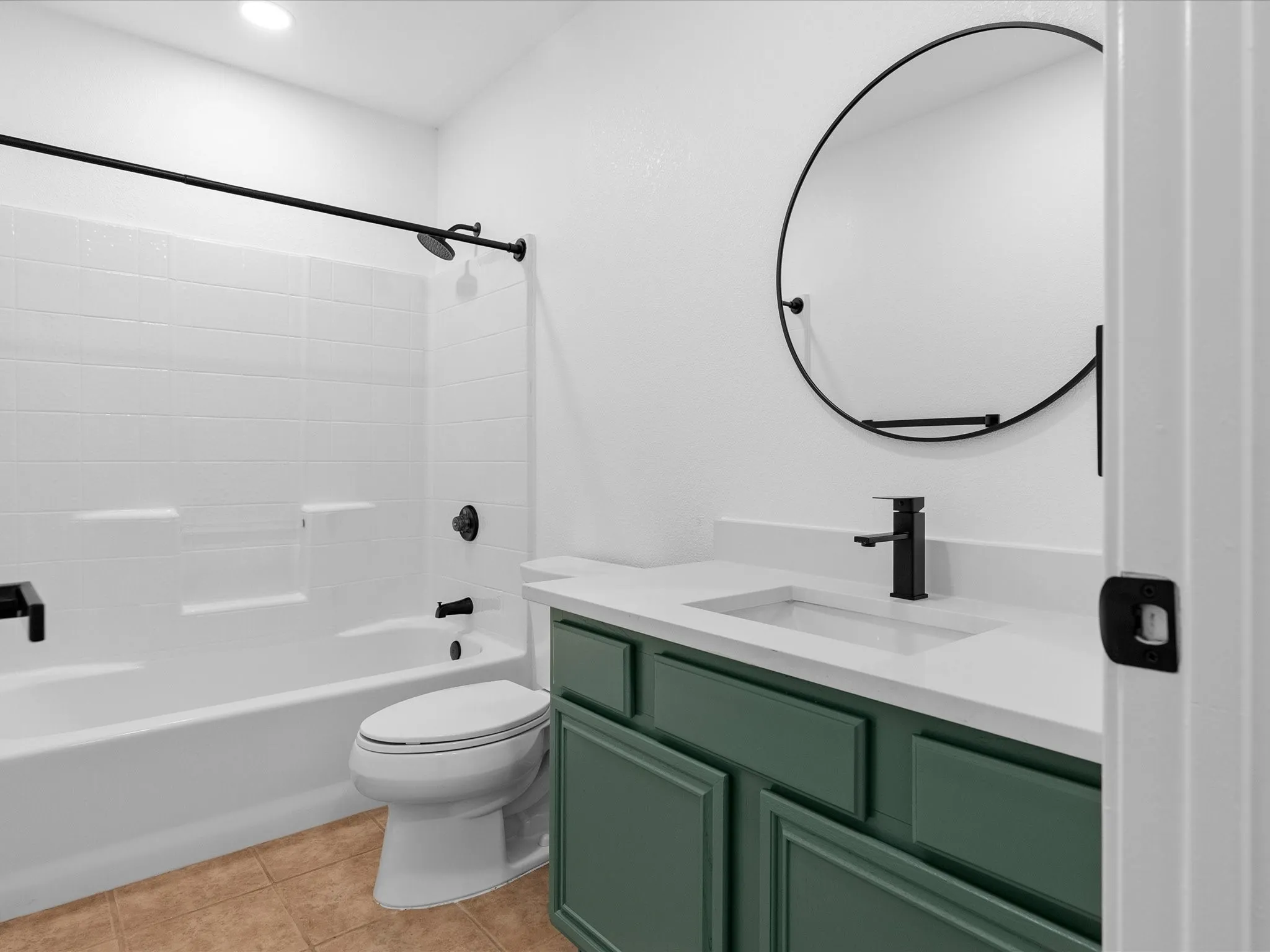 White tub and shower combination with dark-finished fixtures