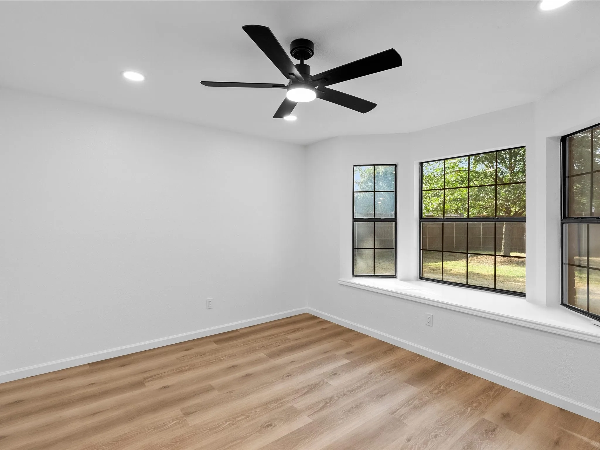 Wood-finish flooring, recessed lighting, and a modern ceiling fan