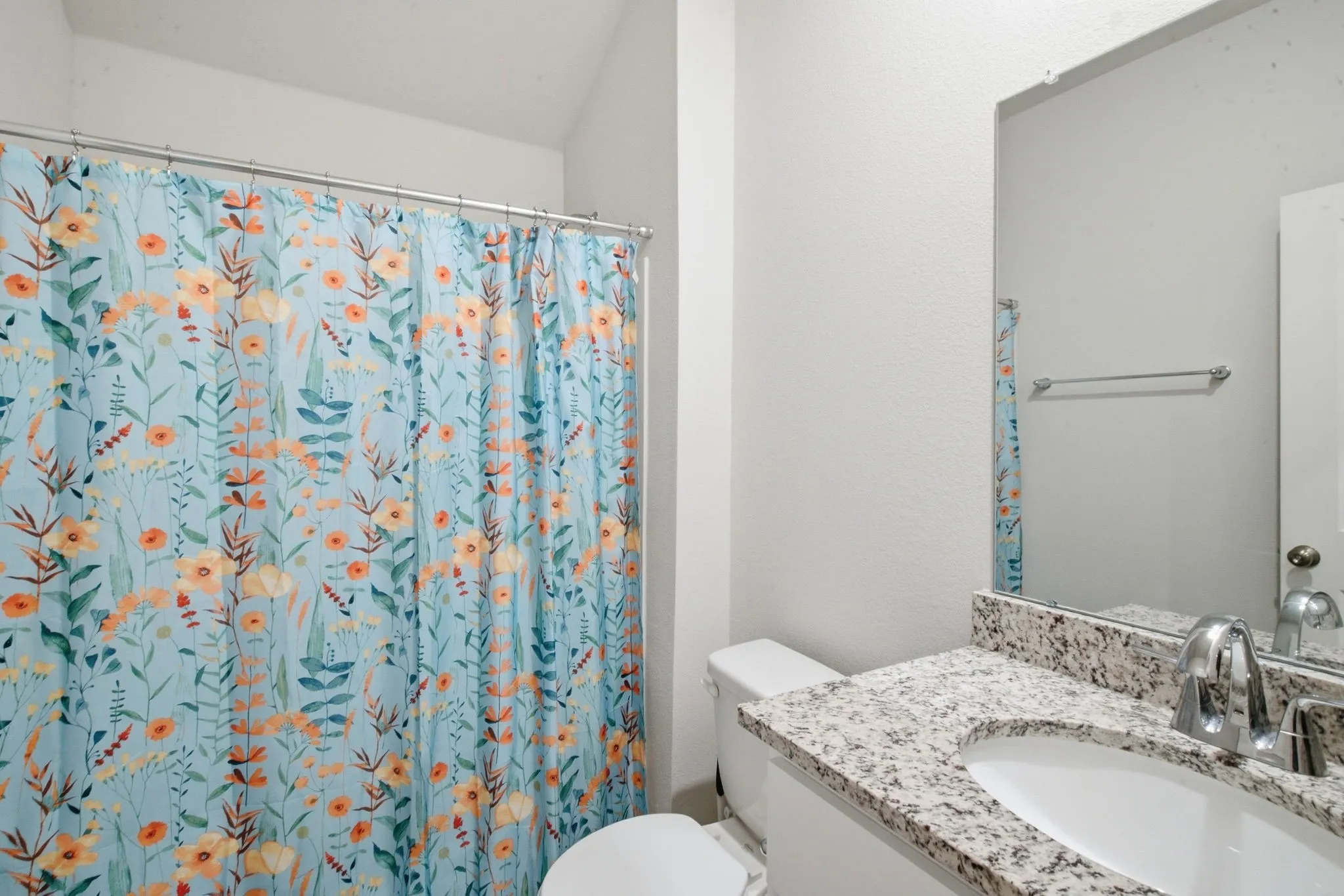 Vanity with a granite-style countertop, undermount sink, and chrome faucet