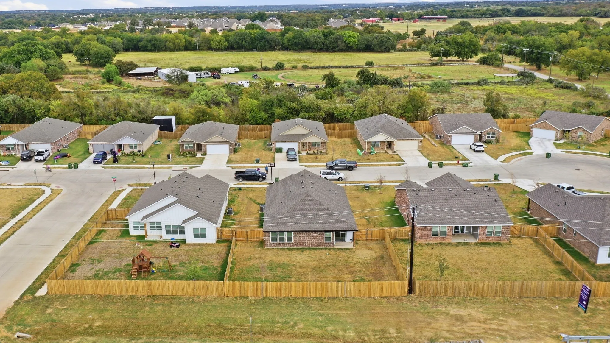 Newly constructed homes with individual wooden privacy fencing and attached garages