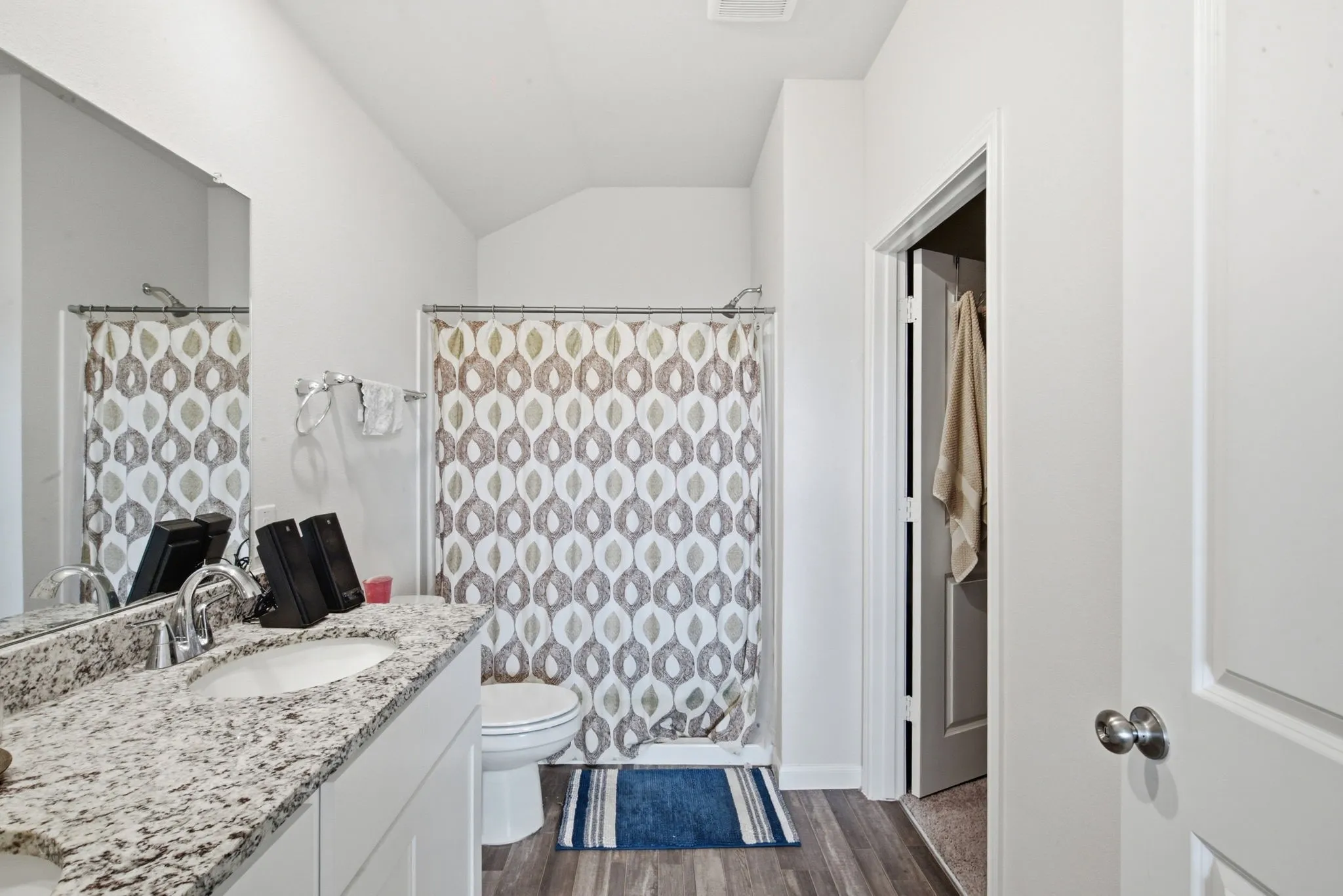 Bathroom featuring a vanity with a light-toned speckled countertop, undermount sink, and chrome faucet