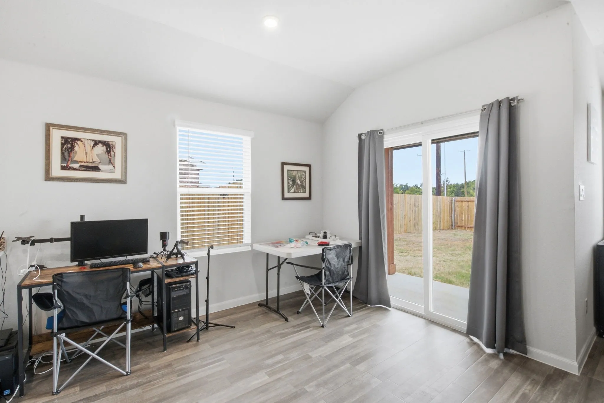 Wood-finish flooring, recessed lighting, a window with blinds, and a sliding glass door providing access to the backyard