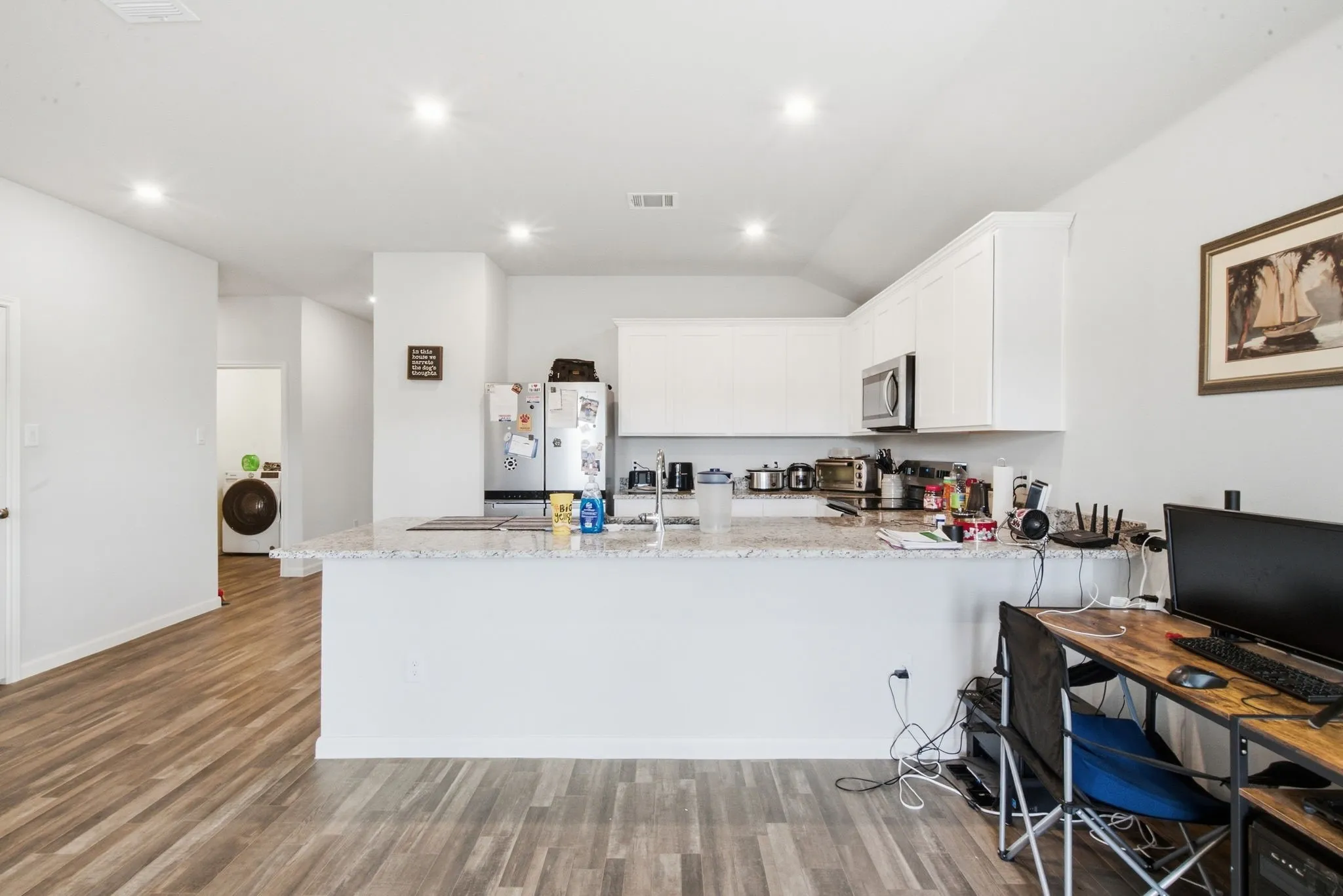Kitchen featuring white cabinetry, light-toned countertops, and stainless steel appliances