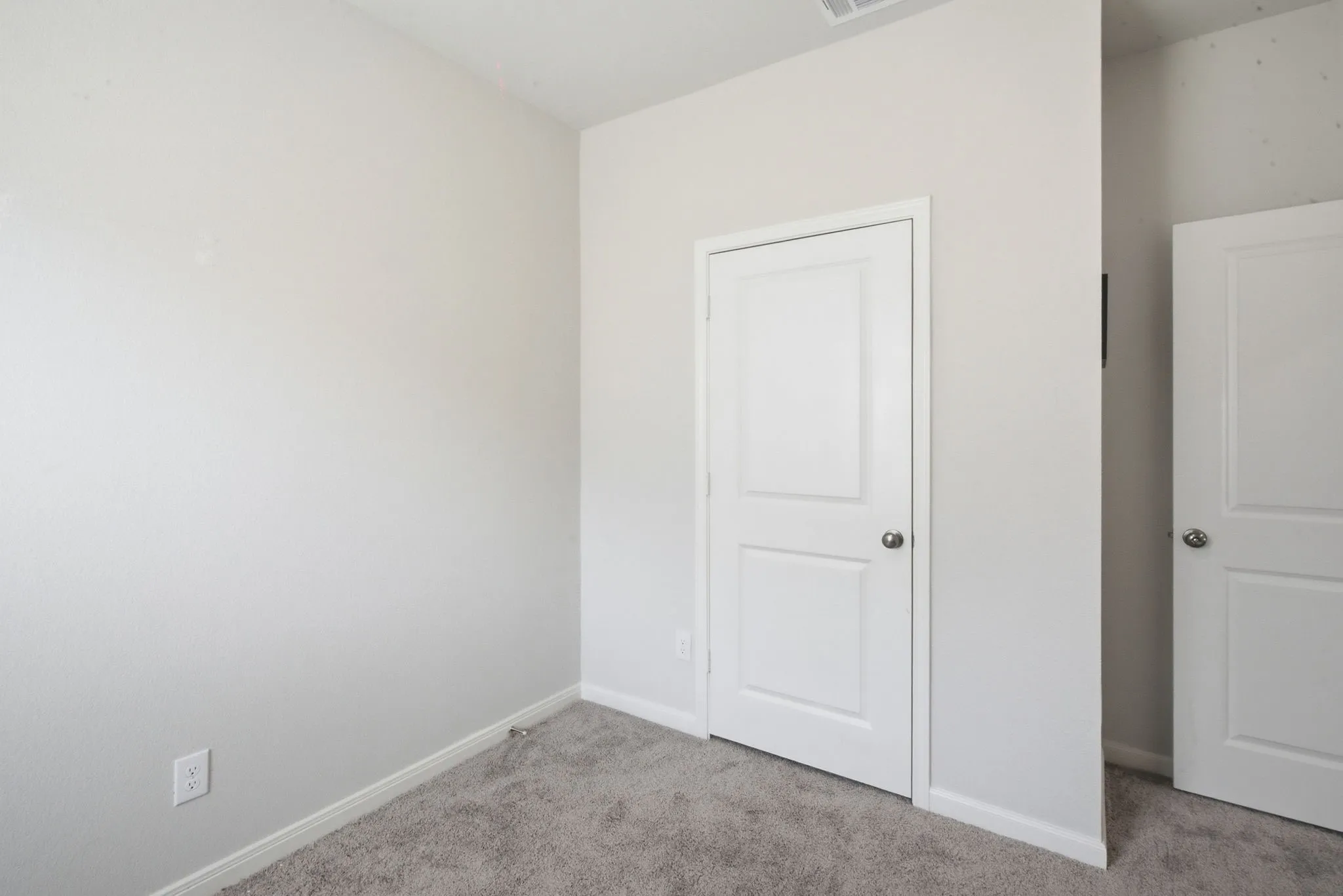 Neutral wall paint complemented by two-panel interior doors with chrome hardware