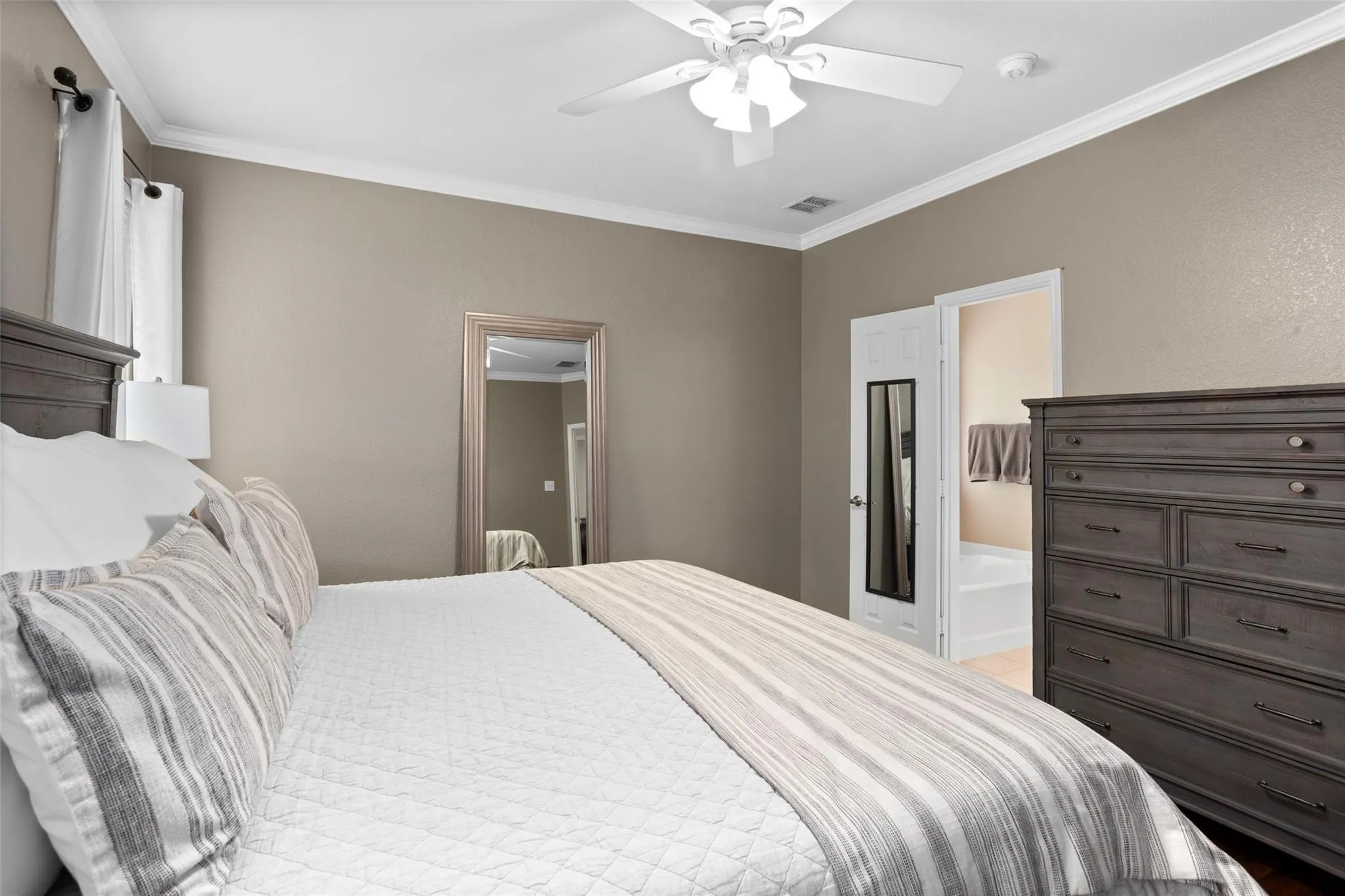 Crown molding accents the ceiling, complemented by a white ceiling fan with integrated lighting