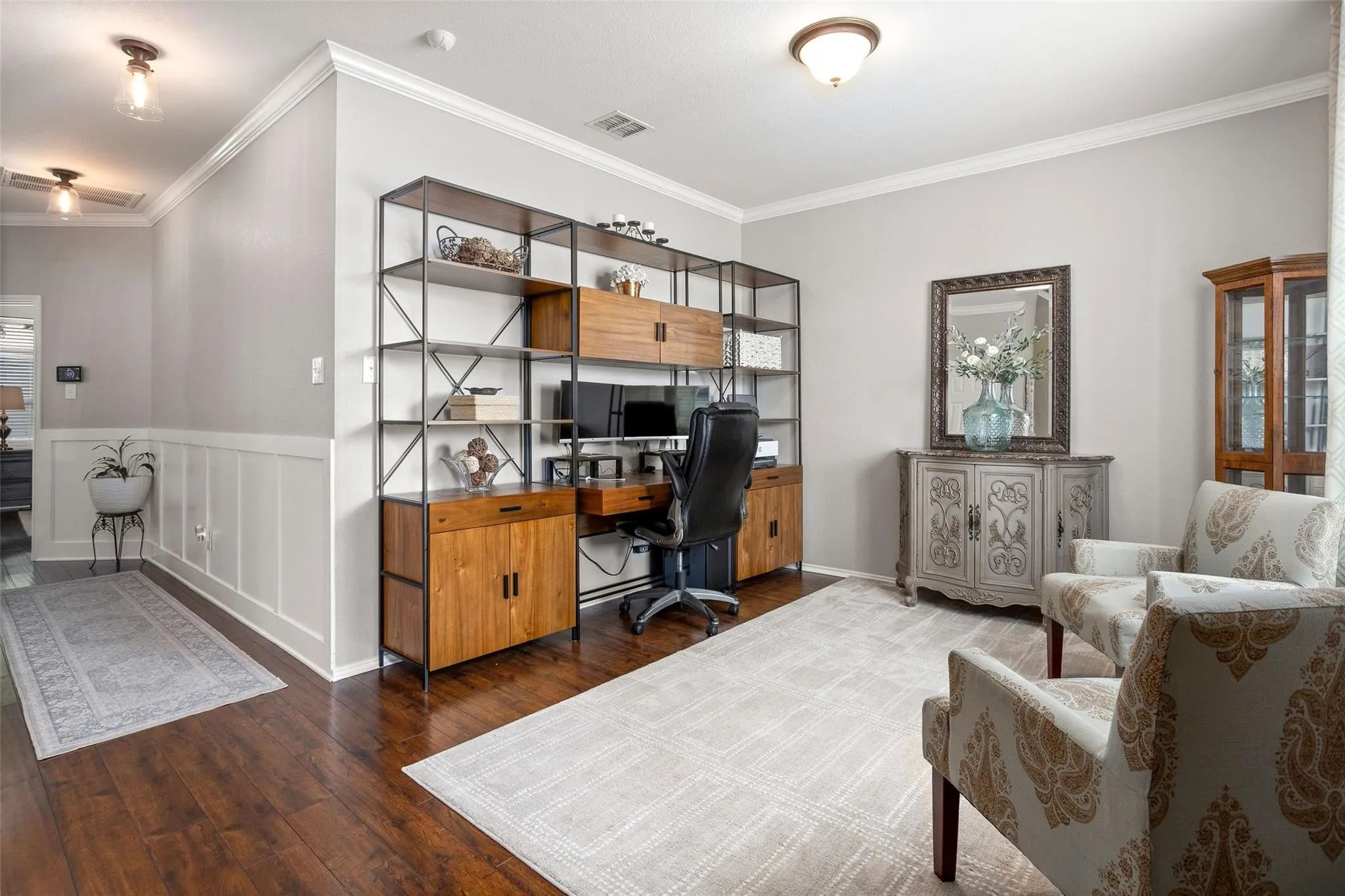 Wood-finish flooring throughout, featuring a built-in shelving unit with integrated desk space