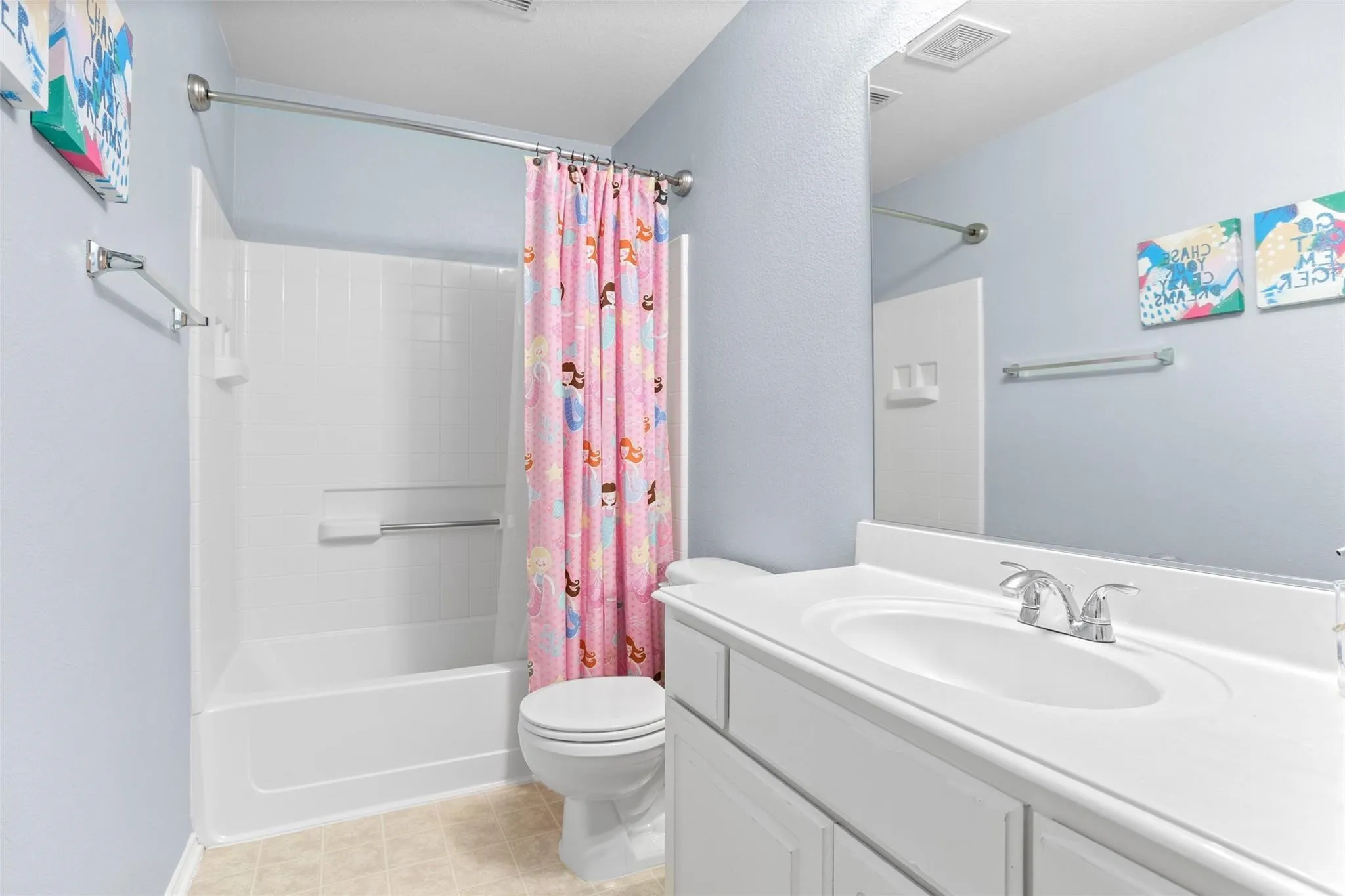 White vanity with integrated sink, chrome faucet, and expansive mirror