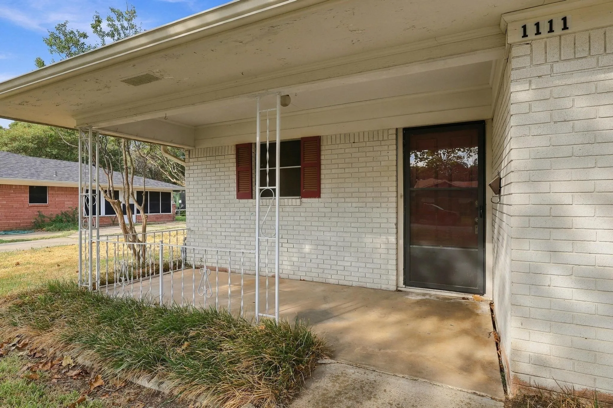 Front porch with concrete flooring and white metal railing