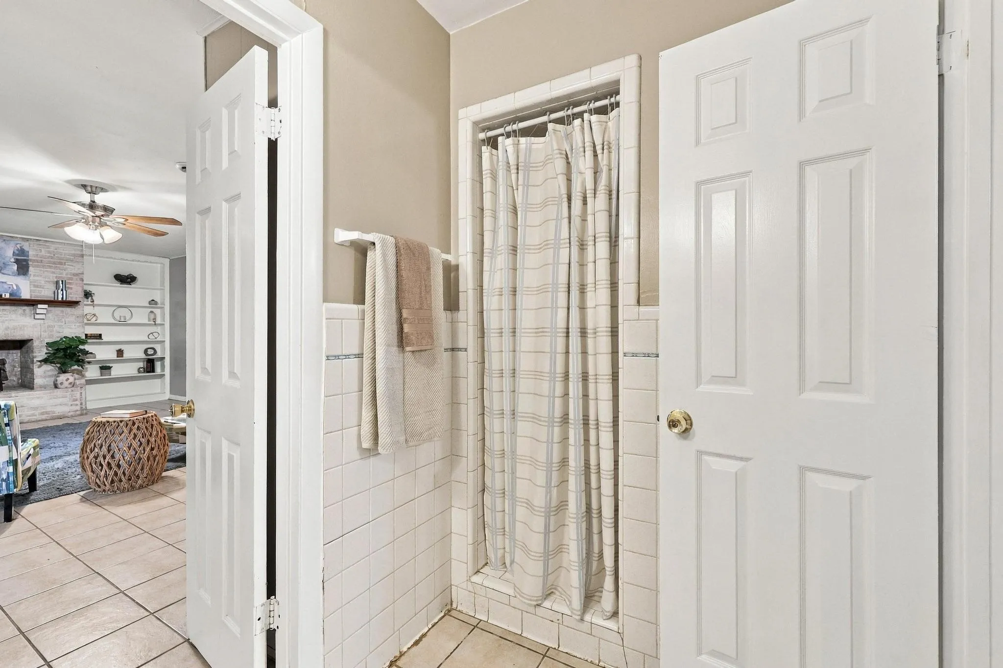 Tiled shower with a white subway tile surround and coordinating floor tiles