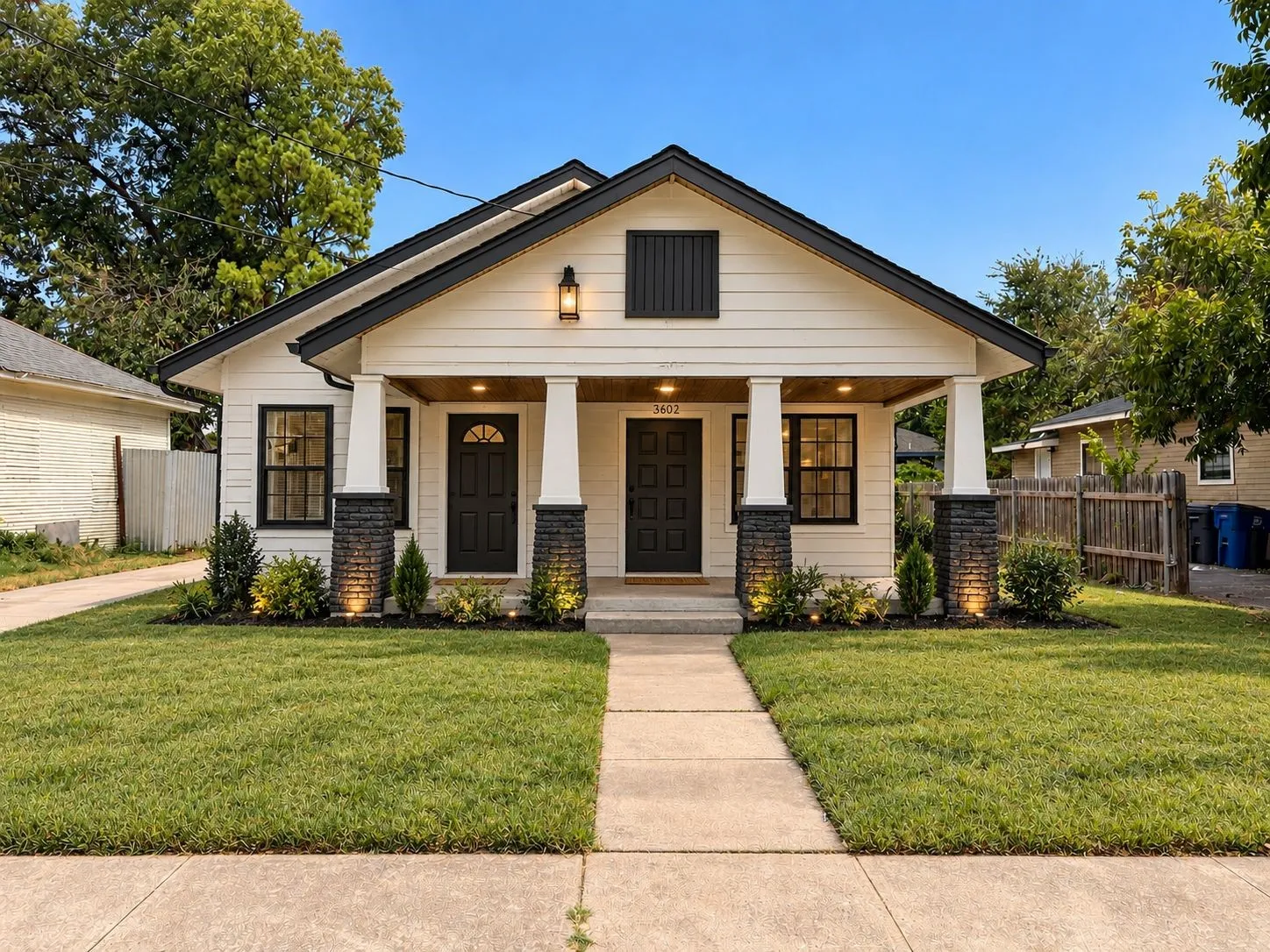 White horizontal siding exterior with black trim and a covered front porch featuring two entries