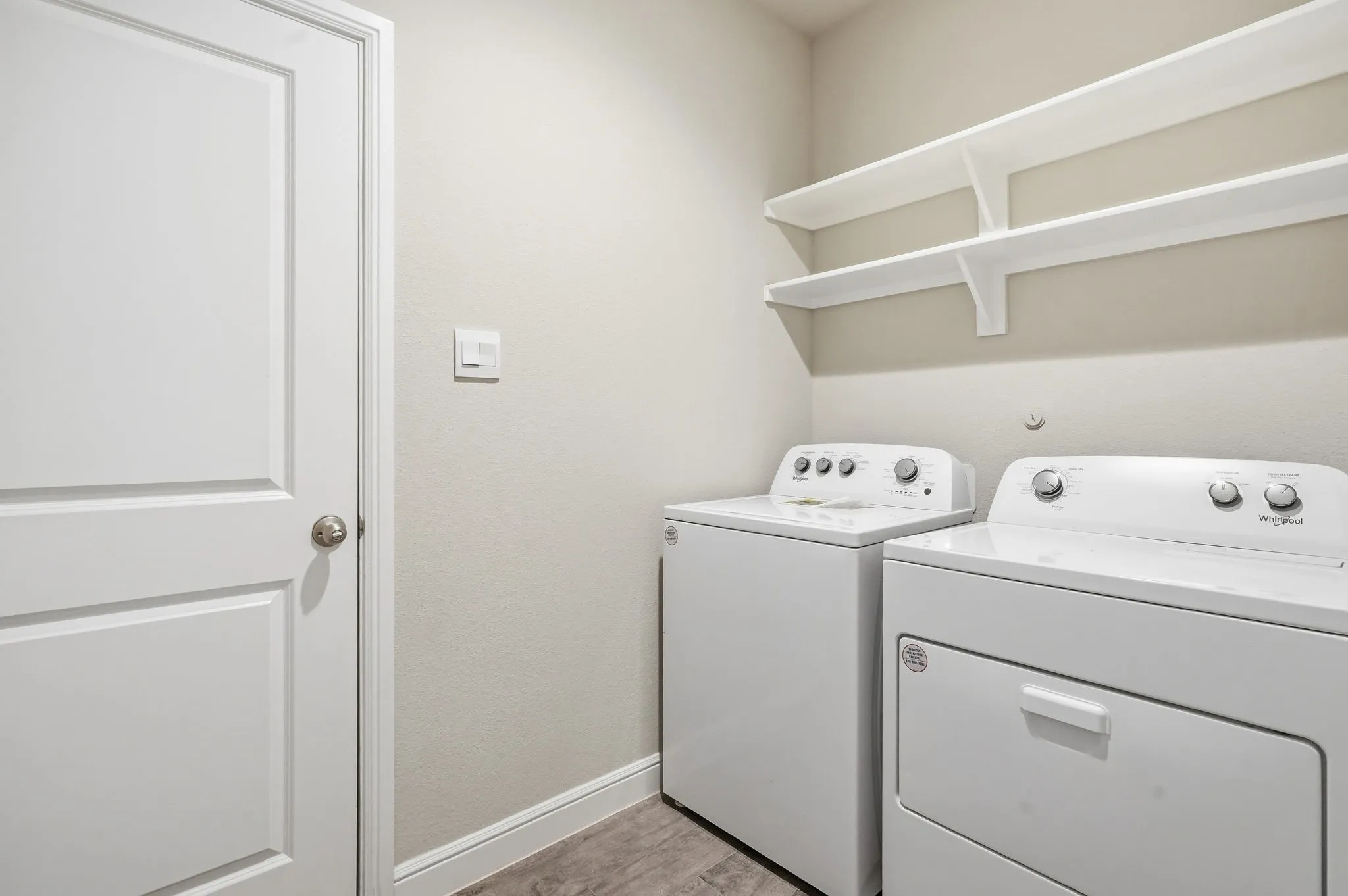 Appliances Stay. Utility room leads to garage and hallway - (virtually staged)