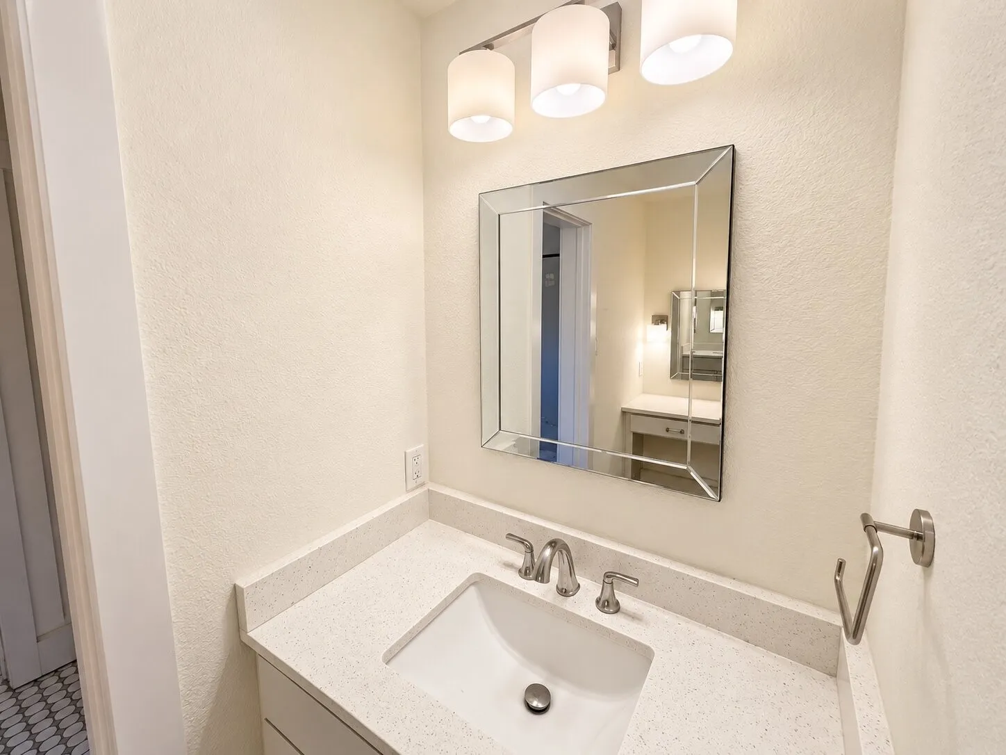 Vanity with integrated sink, chrome faucet, and white countertop