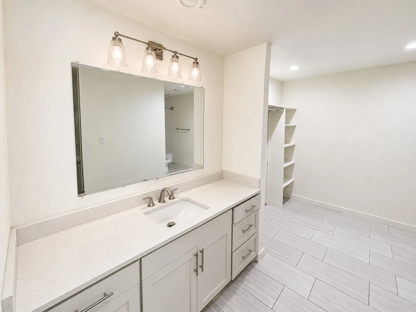 Vanity with a rectangular undermount sink, light-colored countertop, and brushed nickel faucet