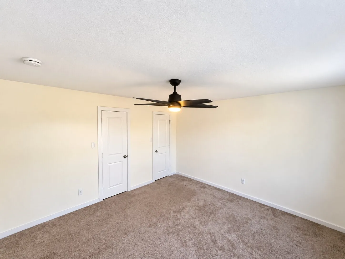 Wall-to-wall carpeting, two panel doors, ceiling fan with integrated lighting, and neutral wall tones