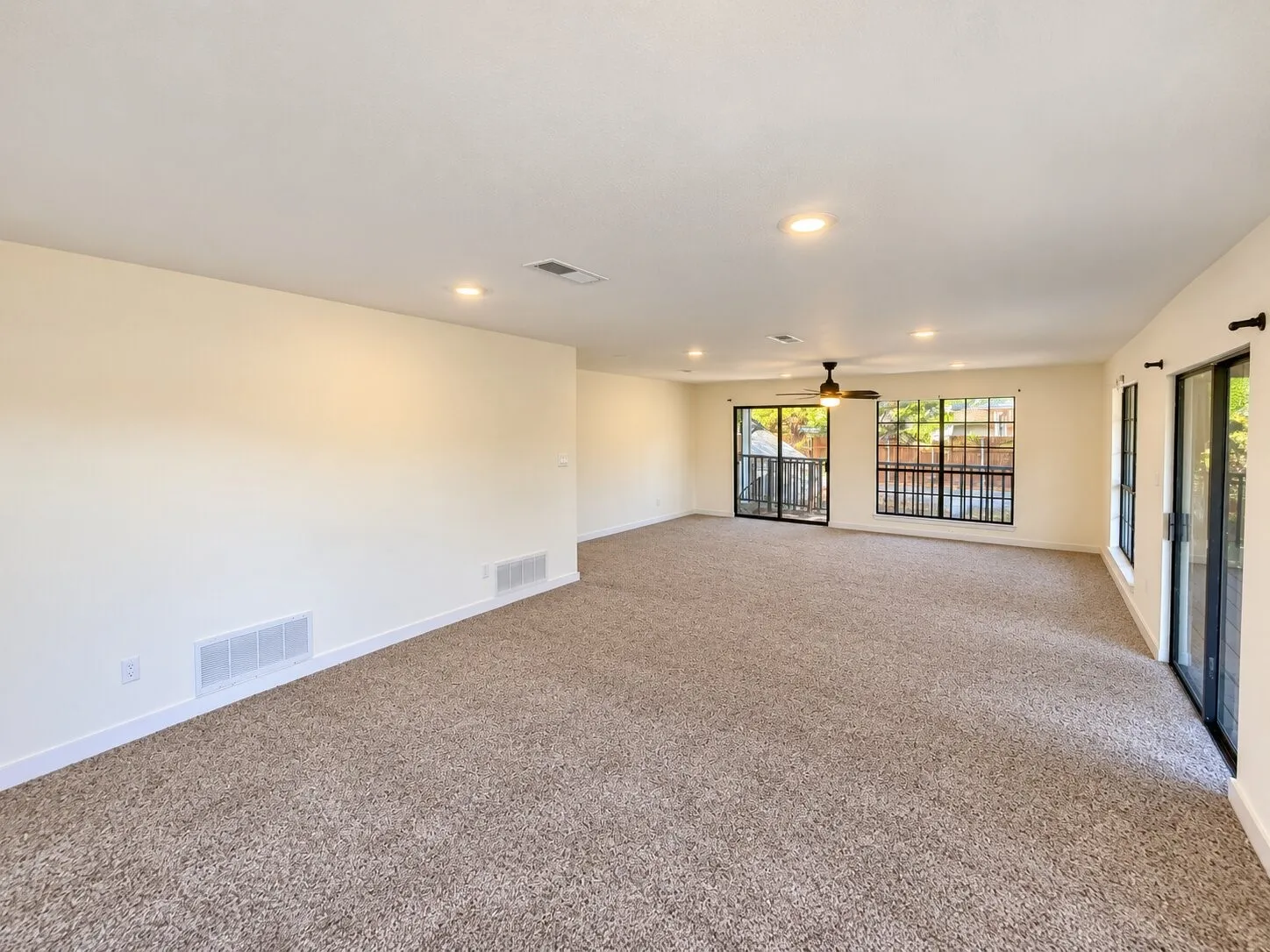 Spacious room with carpeted flooring, recessed lighting, and a ceiling fan