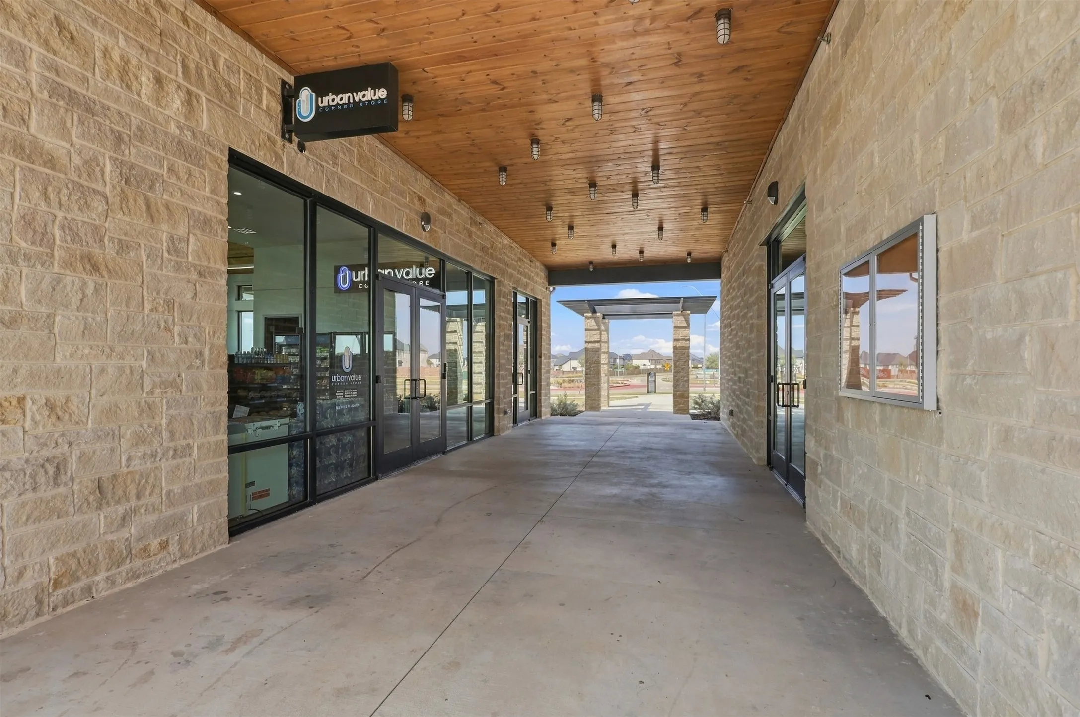 Stone facade featuring large windows and wood-paneled ceiling