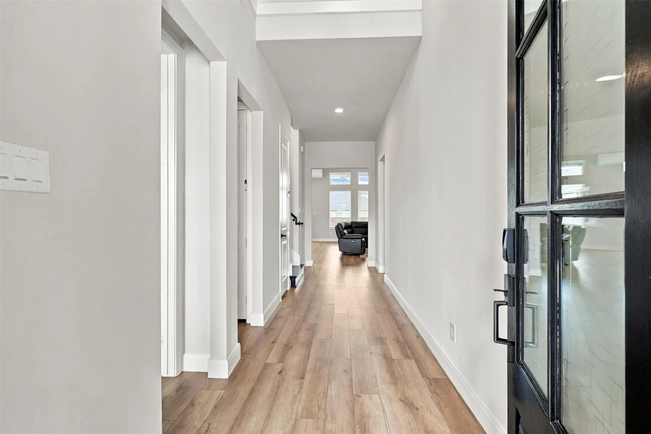 Wood-finish flooring throughout, white wall finishes, and recessed lighting