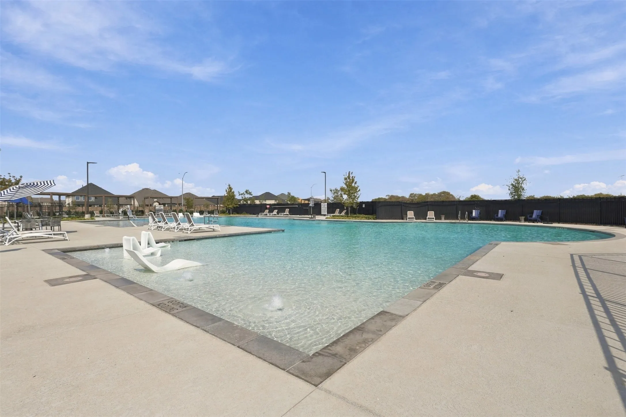 Expansive swimming pool with integrated tanning ledge and water features
