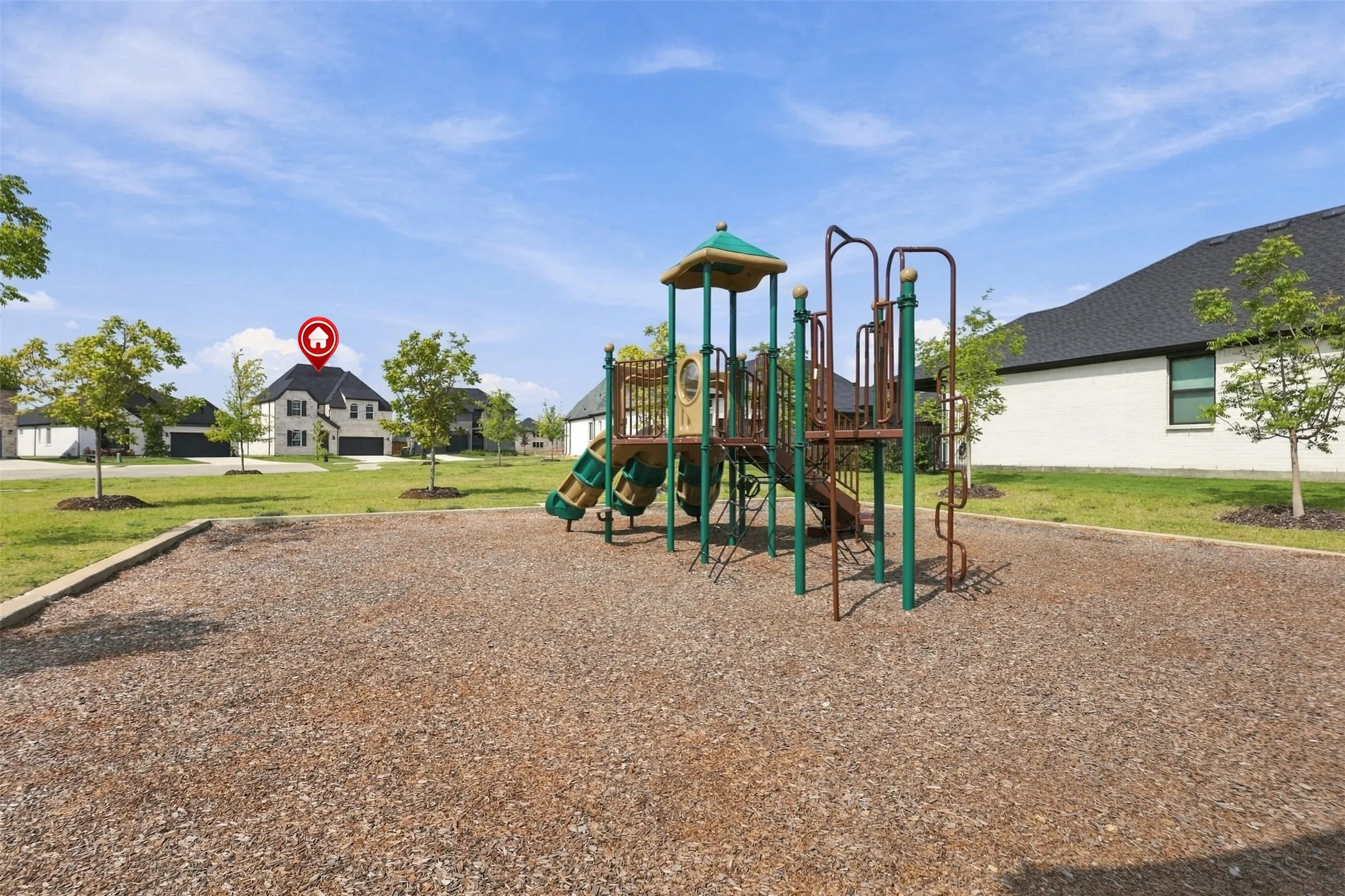 Recreational play structure with slides and climbing elements, set on a wood chip surface