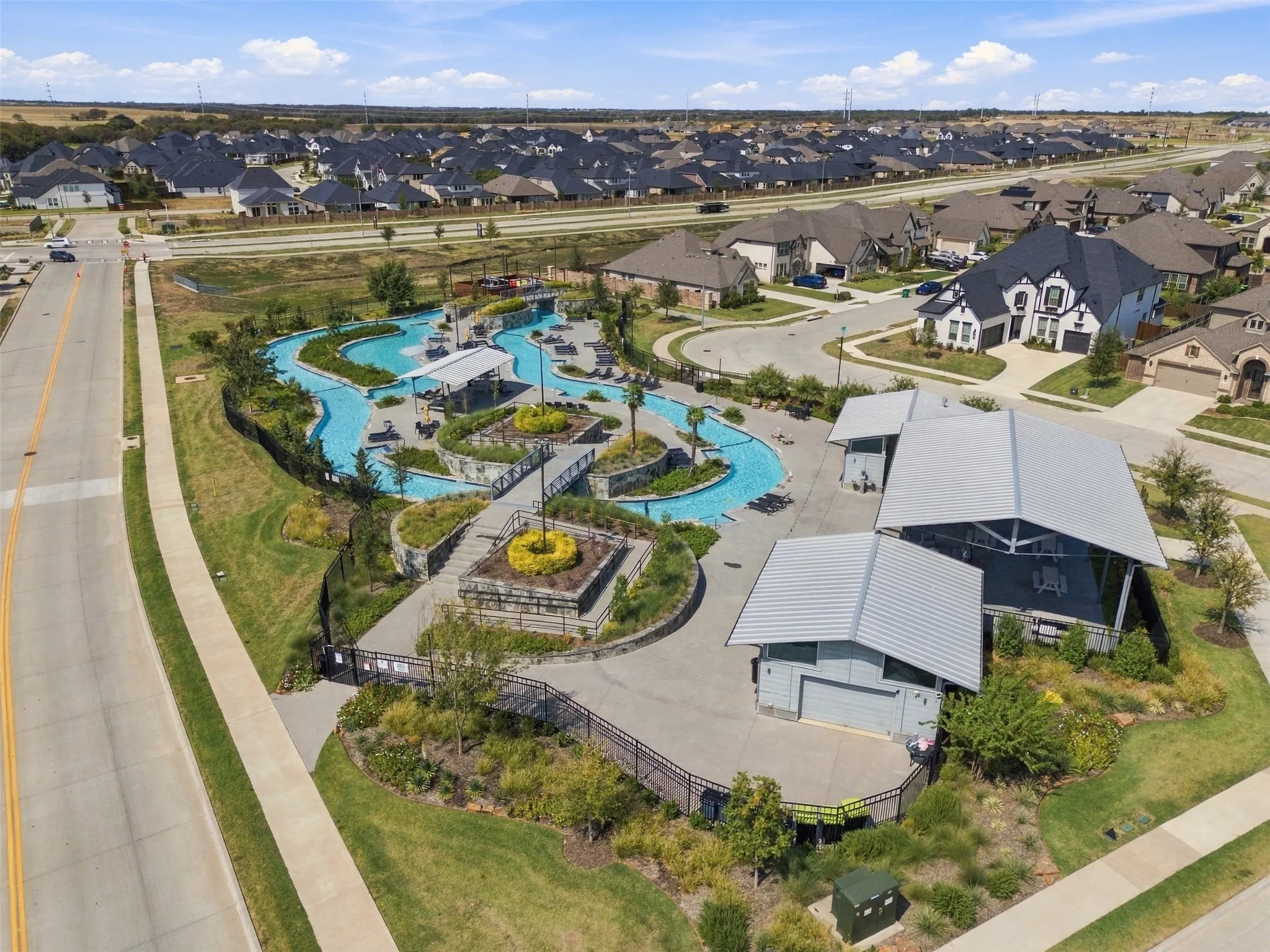 Expansive community water feature with multiple bridges and adjacent structures featuring metal roofs
