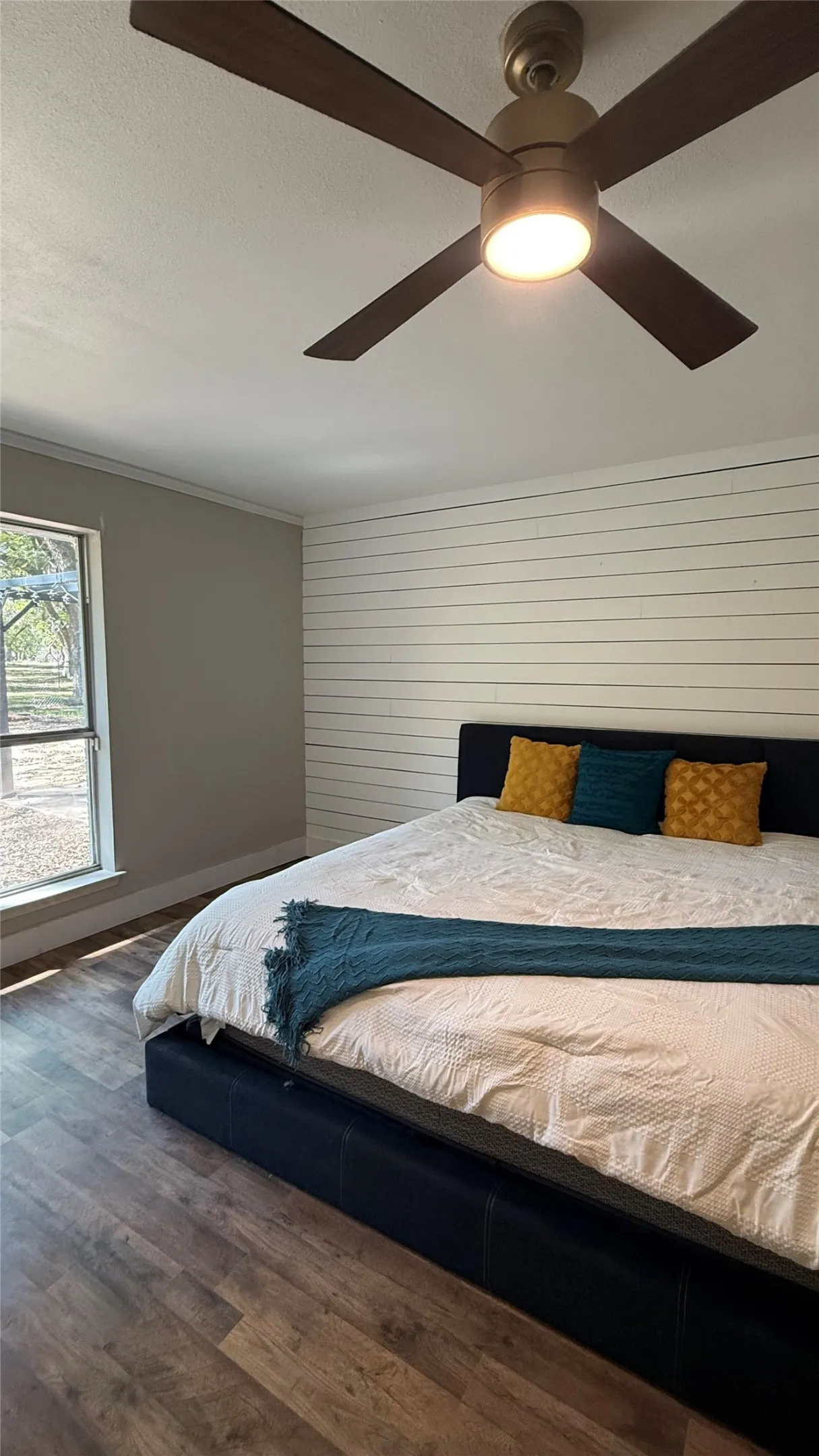 Recessed lighting, wood-finish flooring, shiplap wall and a ceiling fan with integrated lighting