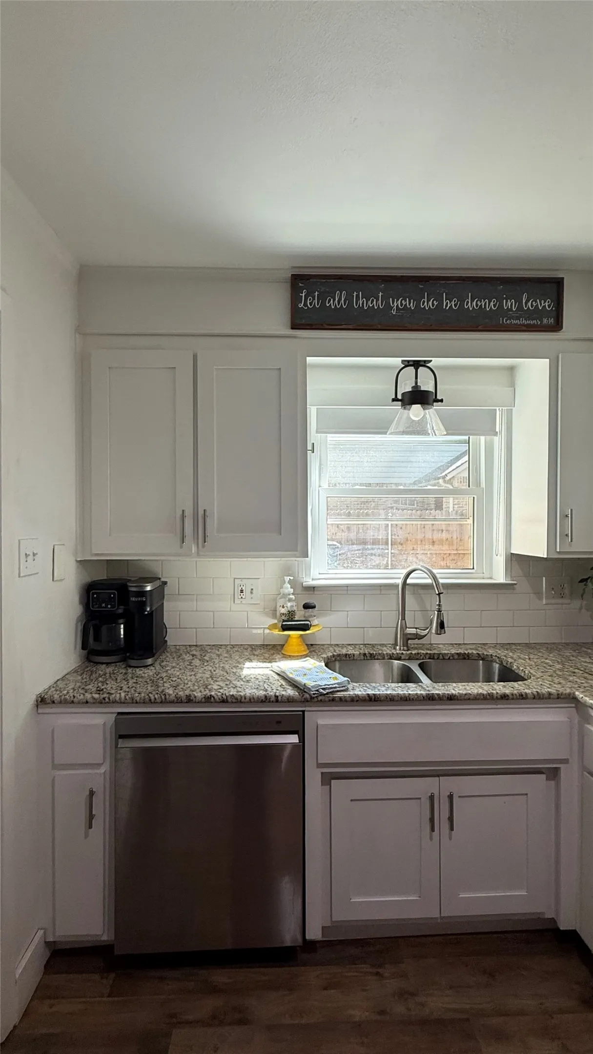 Kitchen featuring white shaker-style cabinetry, granite countertops, subway tile backsplash, stainless steel dishwasher, and a double basin sink with a gooseneck faucet