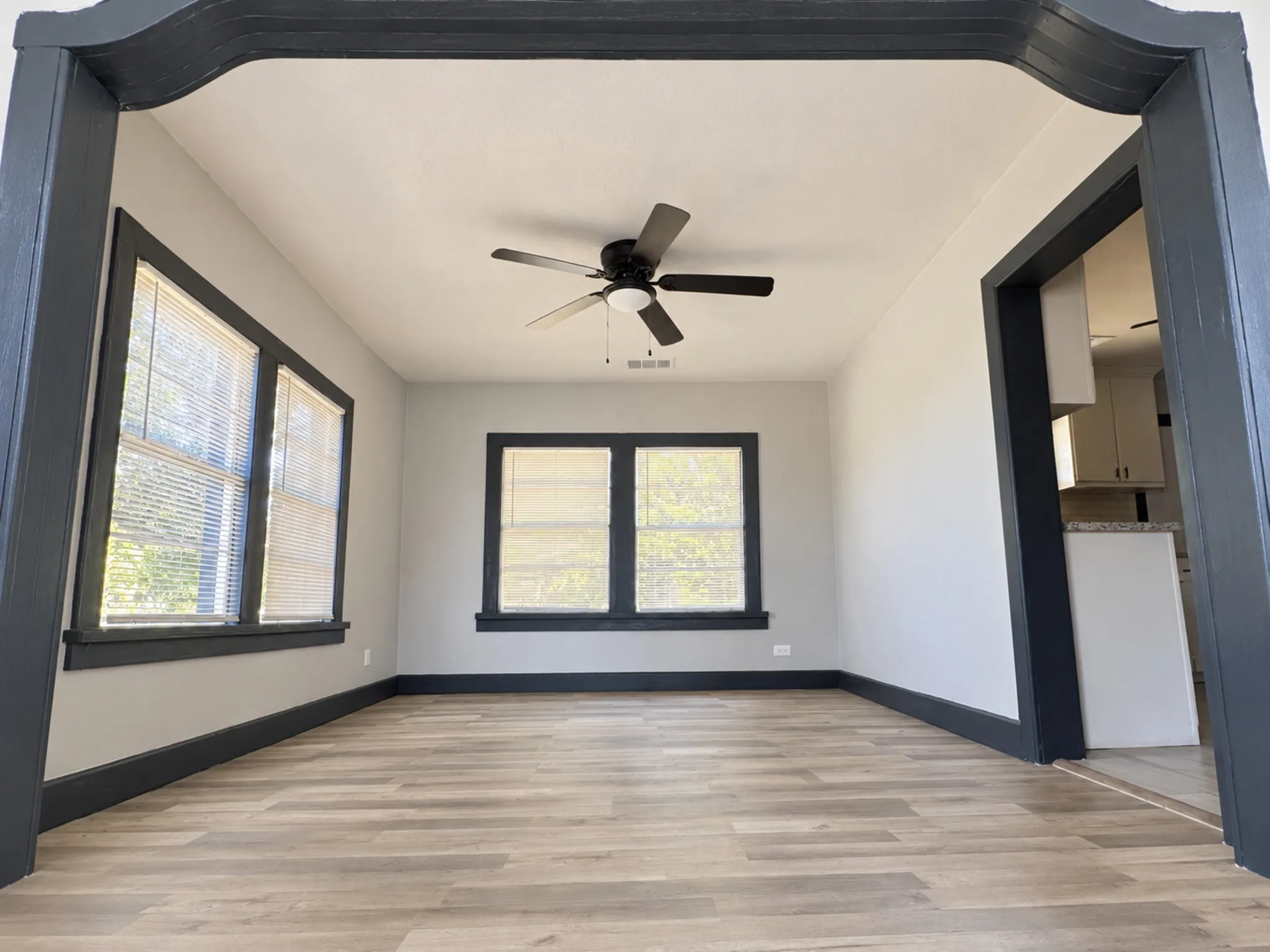 Vinyl style finish flooring, ceiling fan with integrated lighting, multiple windows, and a wide entryway