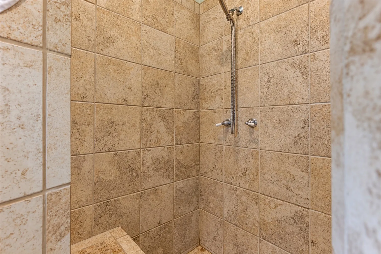 Large, tiled shower with bench