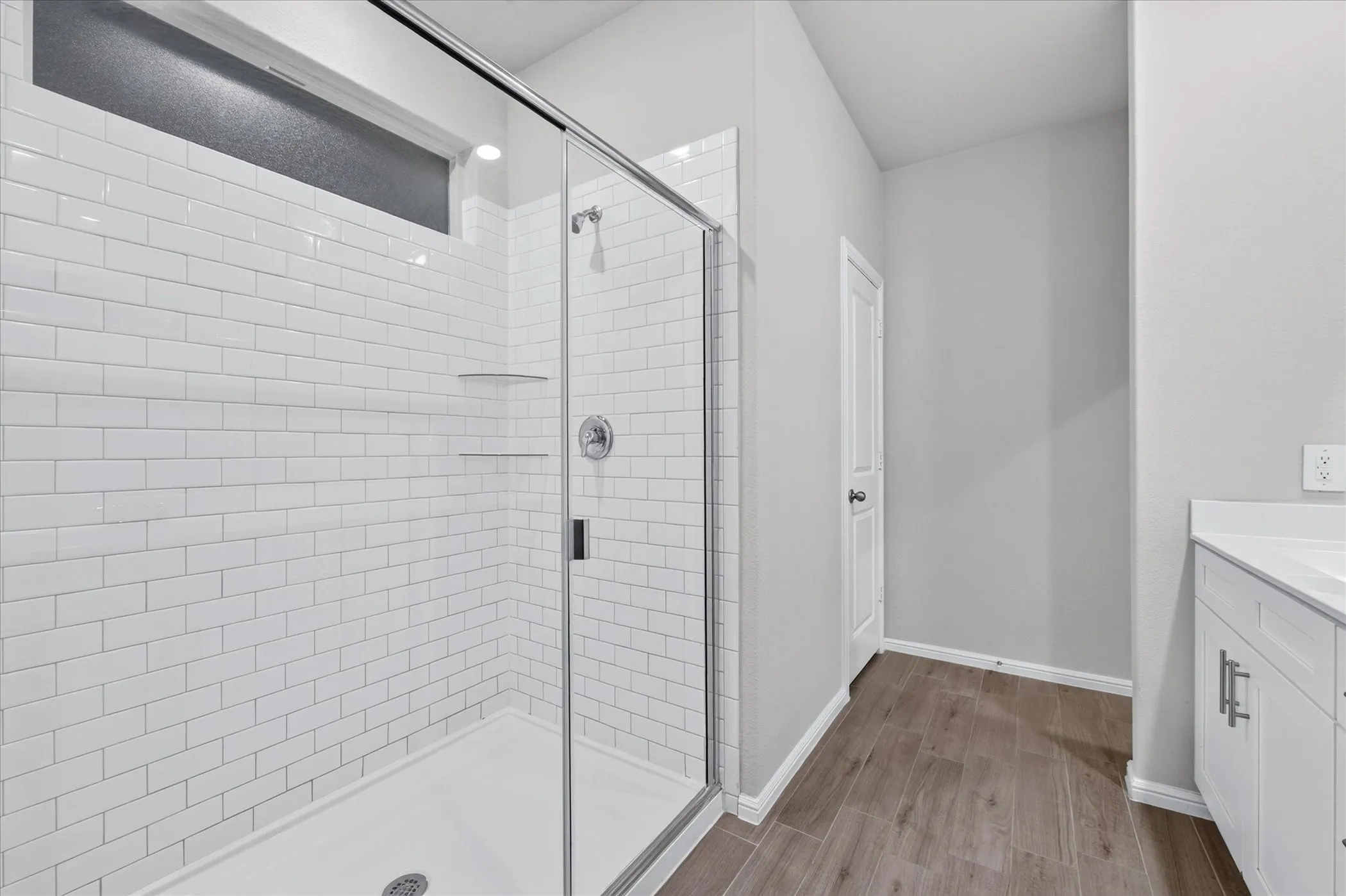 Shower with subway tile surround, glass enclosure, and transom window