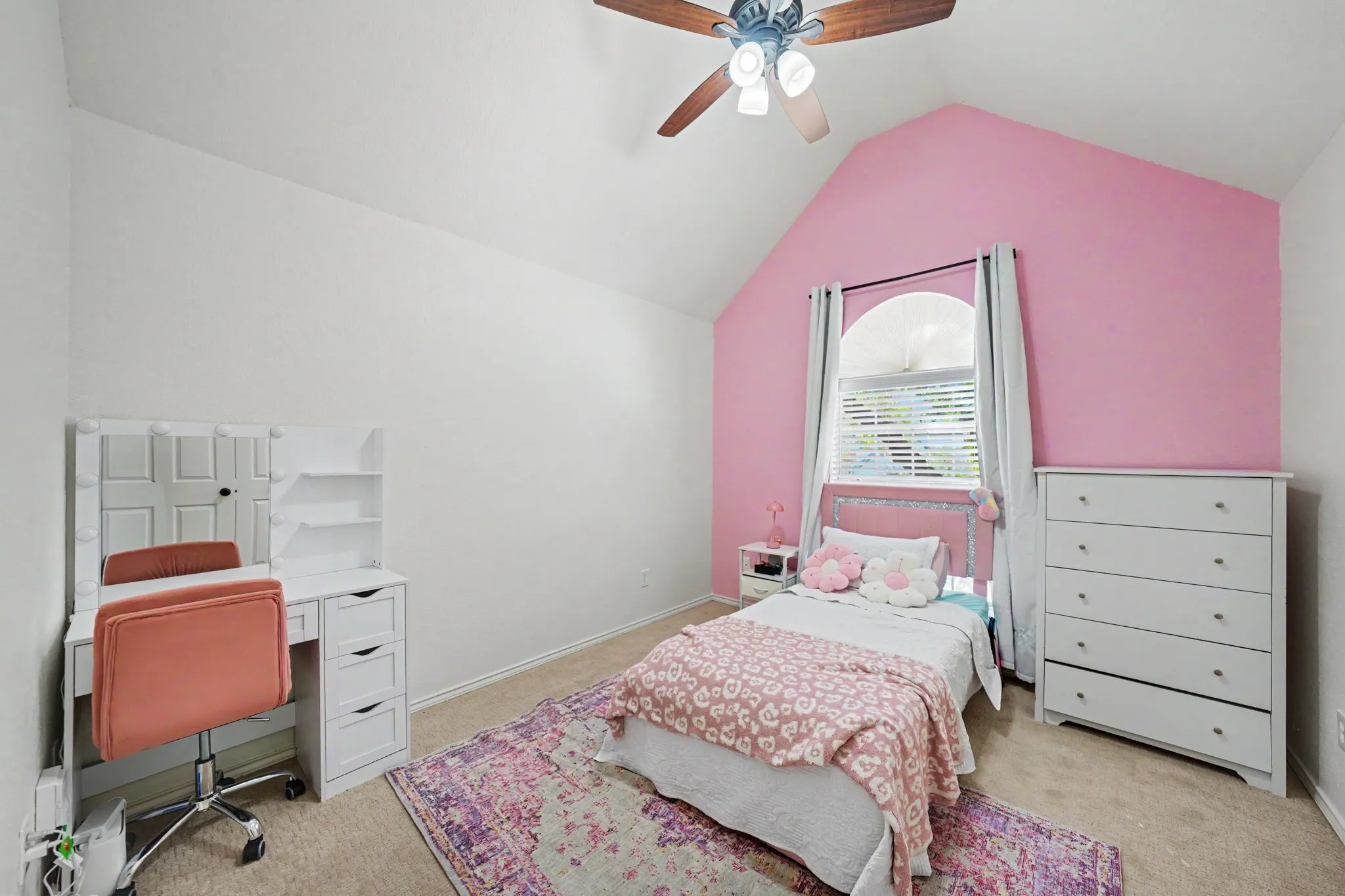 Vaulted ceiling with ceiling fan, arched window with blinds, and carpet flooring