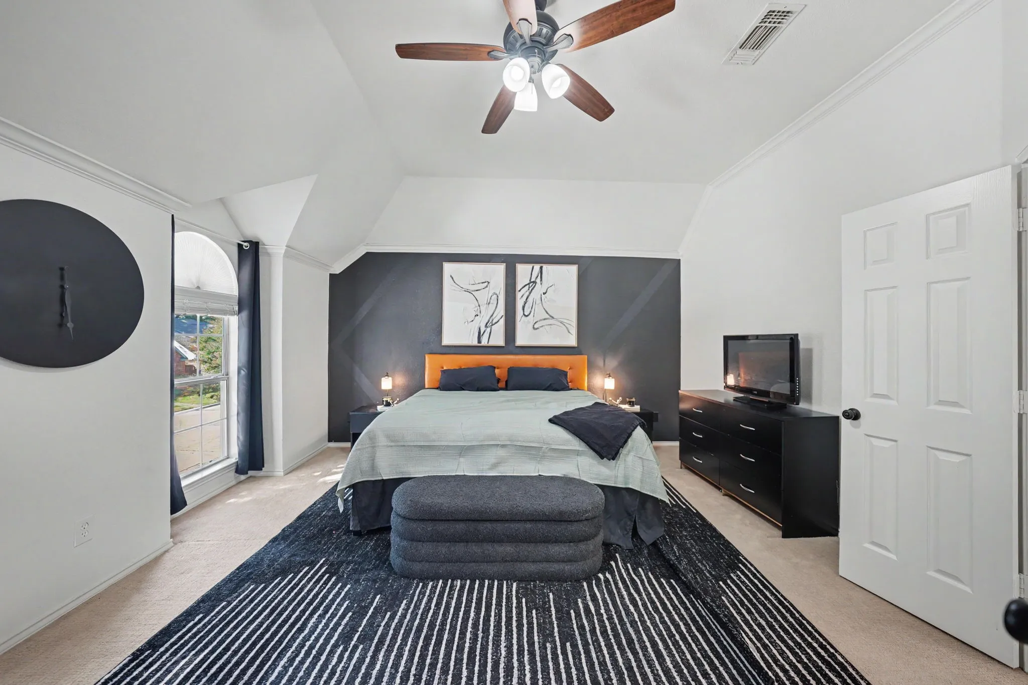 Vaulted ceiling with crown molding, ceiling fan with wood-finish blades, and recessed lighting