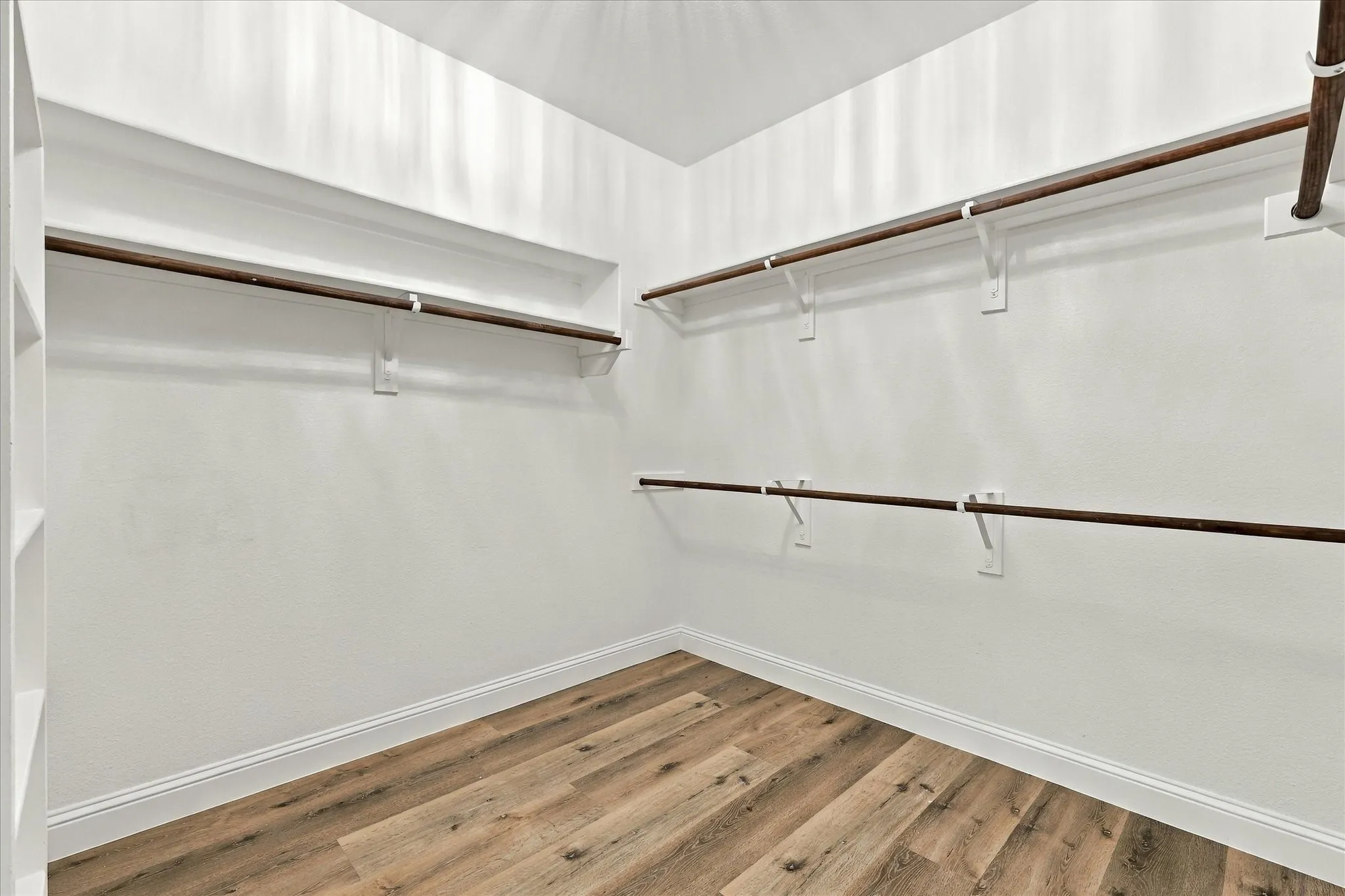 The primary closet offers luxury vinyl plank flooring.