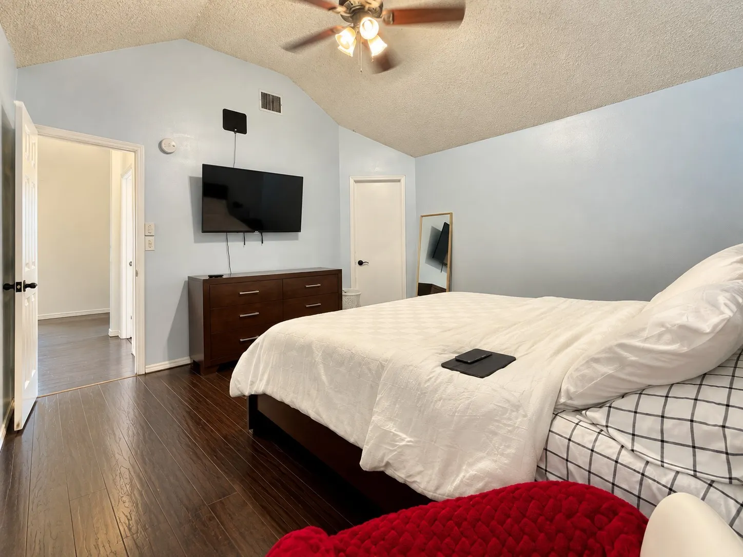Wood-finish flooring, vaulted ceiling, and ceiling fan with light fixture