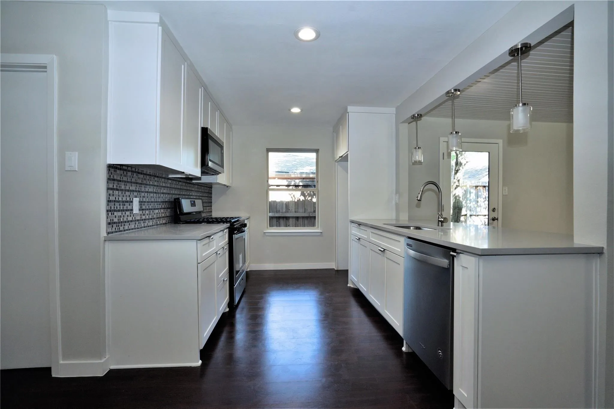 Kitchen featuring appliances with stainless steel finishes, plenty of natural light, tasteful backsplash, light countertops, and recessed lighting