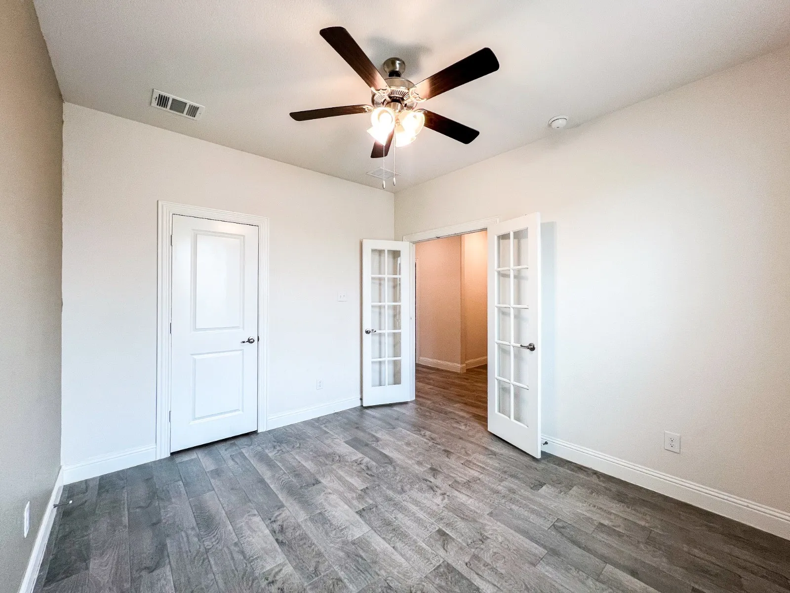 Wood-finish flooring, white walls, white trim, recessed lighting, and a ceiling fan with light fixture