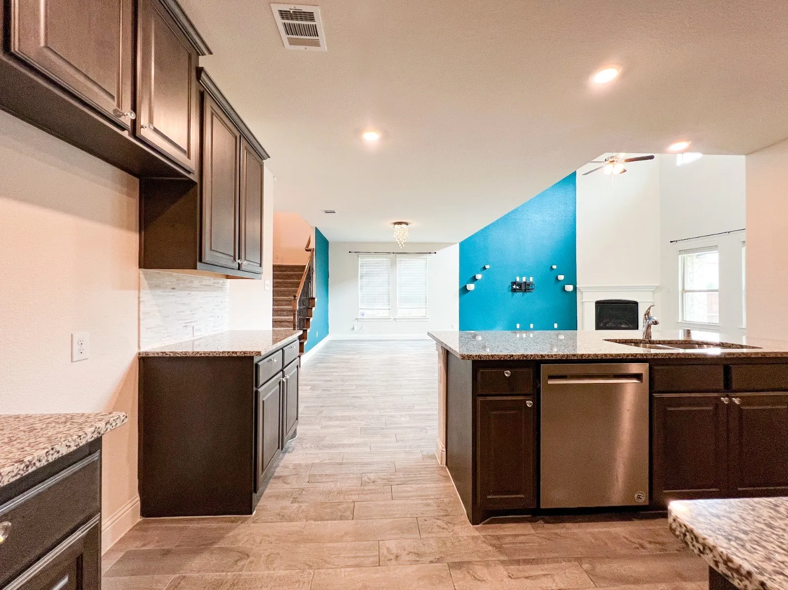 Kitchen island with integrated sink, stainless steel dishwasher, and granite countertops
