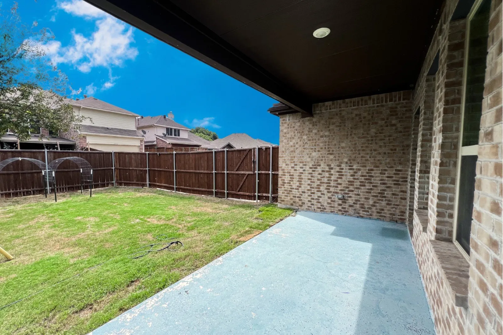 Covered patio with recessed lighting, a brick exterior, and a private fenced backyard with a grass lawn